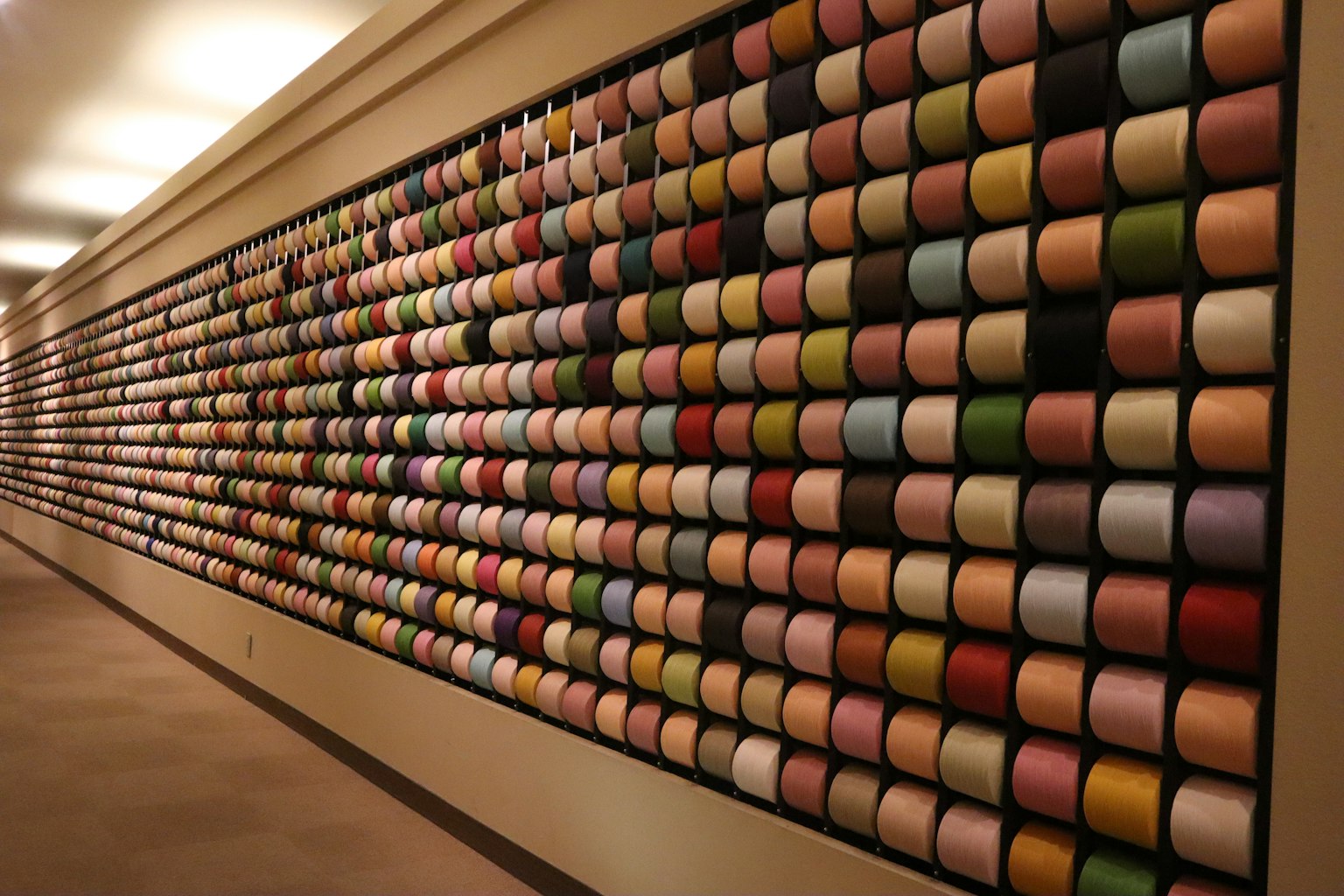 Esposizione colorata di rocchetti disposti su una parete
