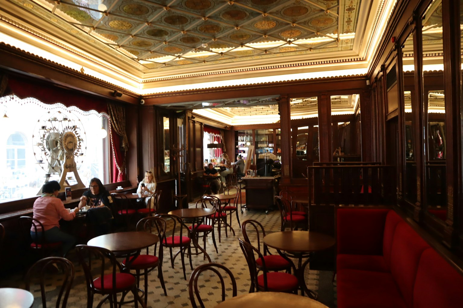 Elegantes Interieur eines Cafés mit Holzmöbeln und roten Sofas