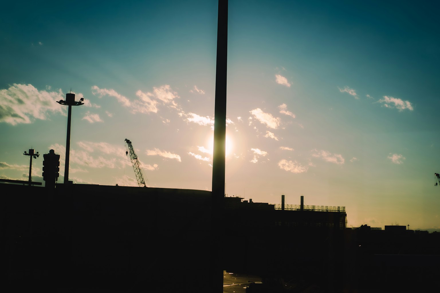 Silhouette di strutture industriali contro un cielo al tramonto