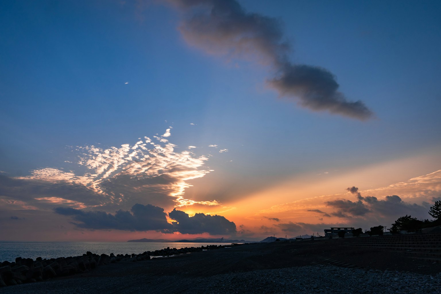 Splendido cielo al tramonto con nuvole e silhouette della costa