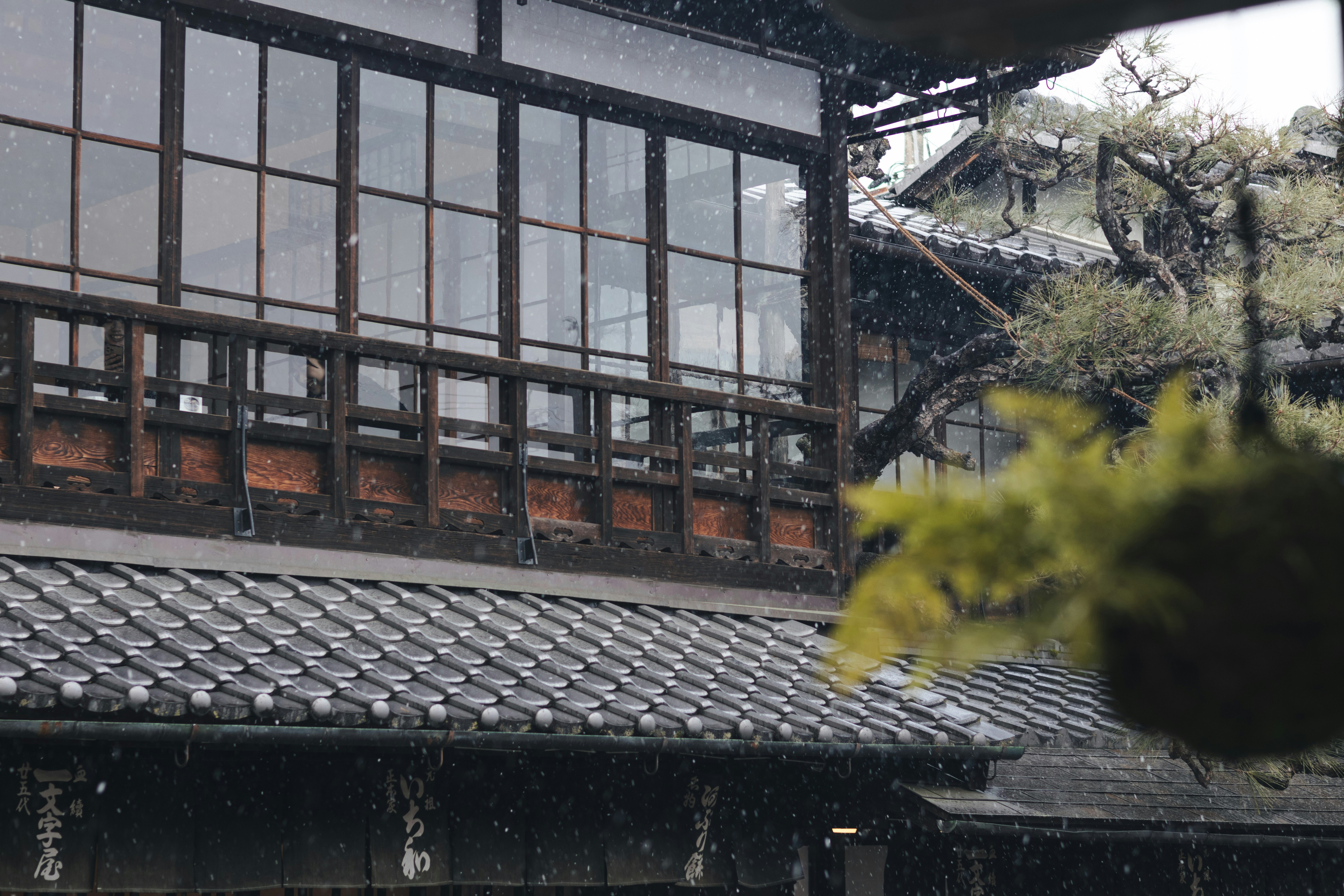 雪落在老式传统民居的屋檐与格子窗上