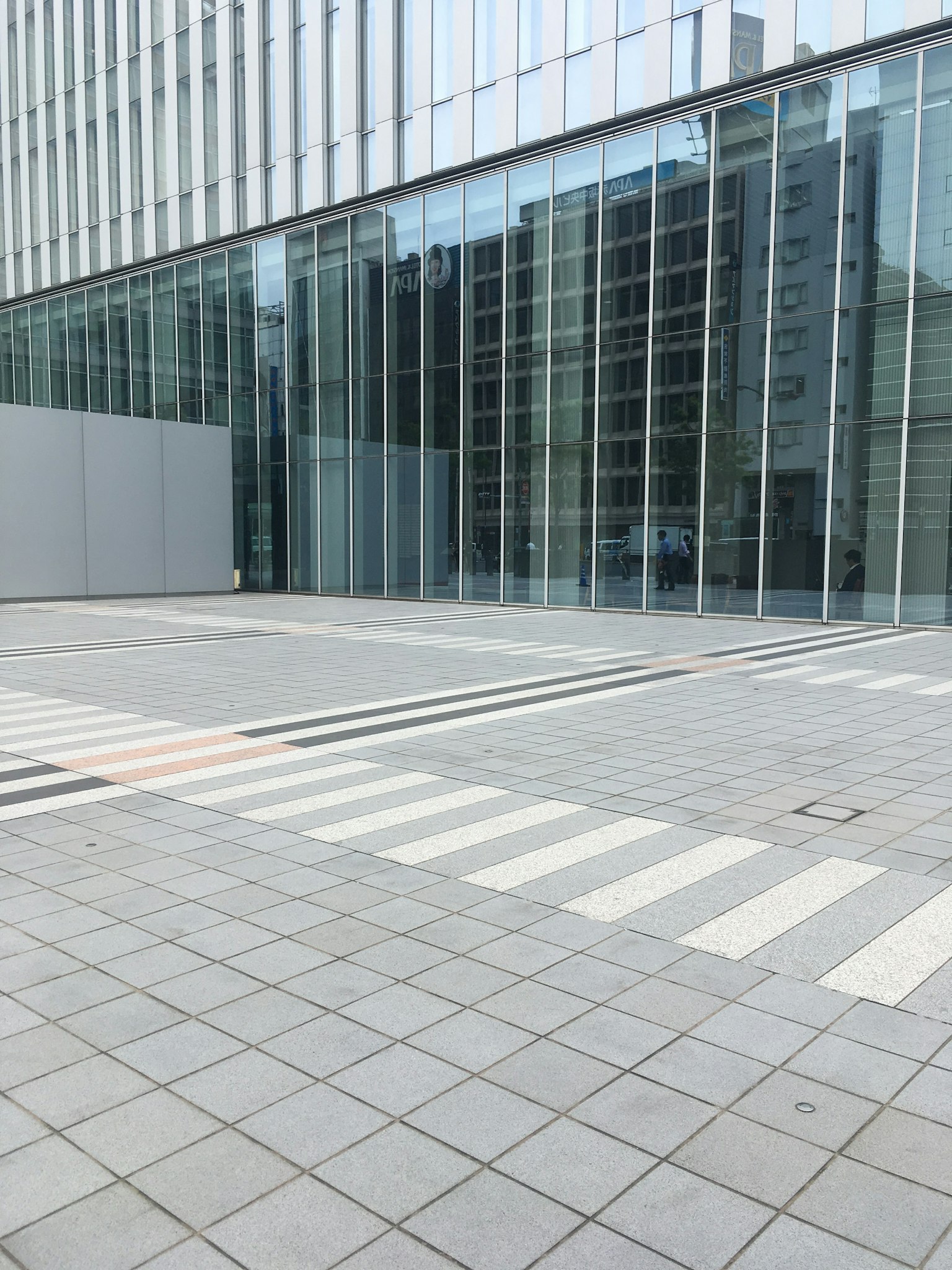Edificio moderno con fachada de vidrio y pavimento de baldosas
