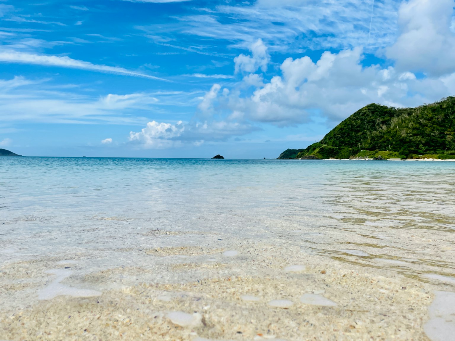 Strandansicht mit klarem Wasser und blauem Himmel