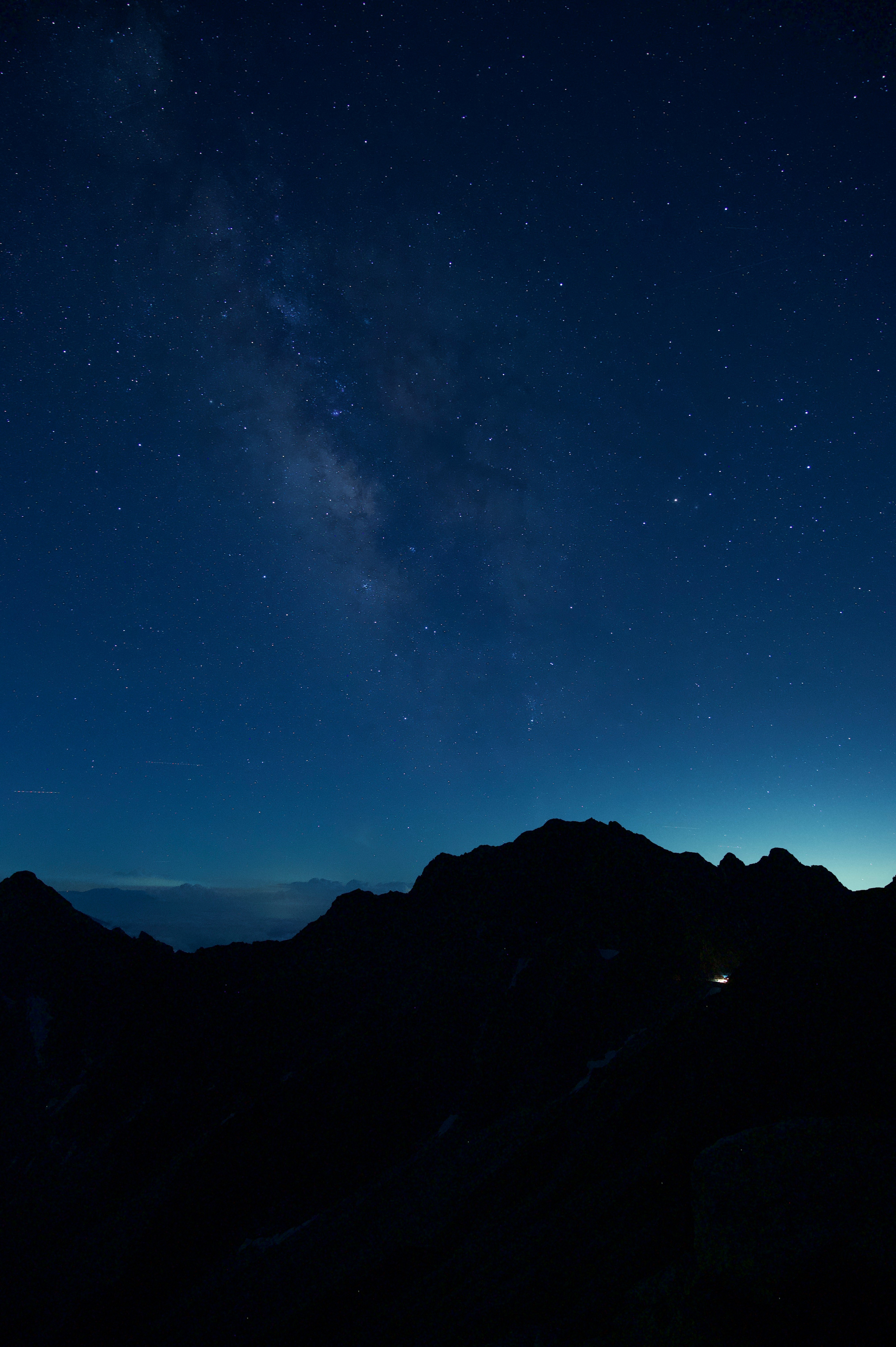 星空の下に浮かぶ山稜のシルエット