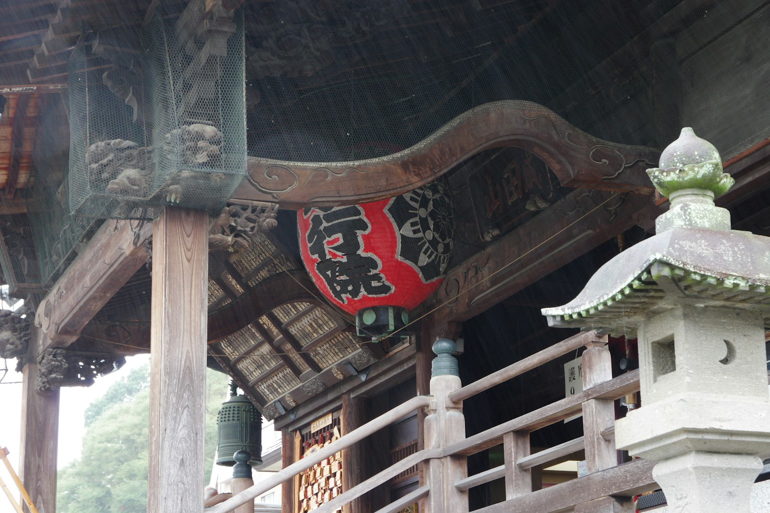 Large lantern under the roof of an old Japanese temple featuring traditional architecture