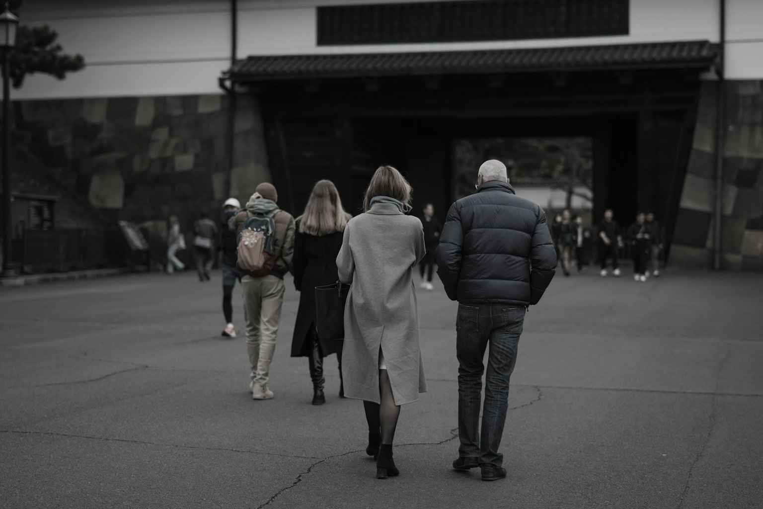 Gruppe von Menschen, die vor einem traditionellen Gebäude gehen