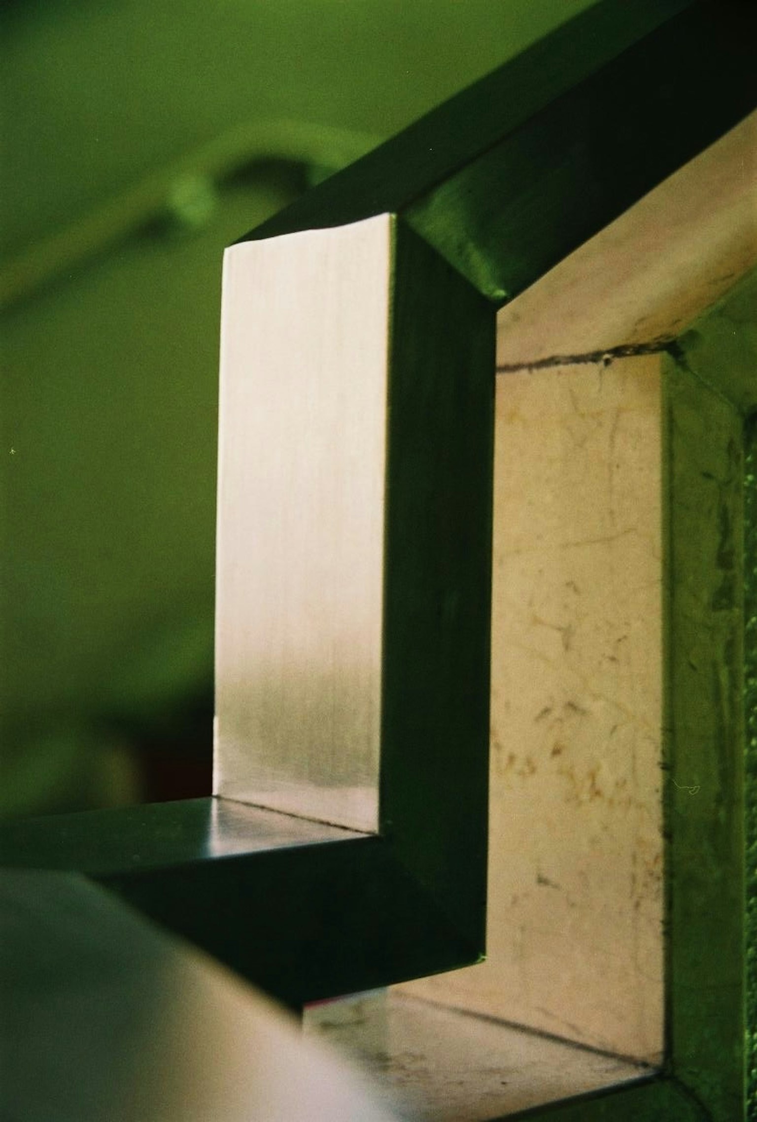 Nahaufnahme einer Metallgeländer-Ecke vor einem grünen Hintergrund mit elegantem Design