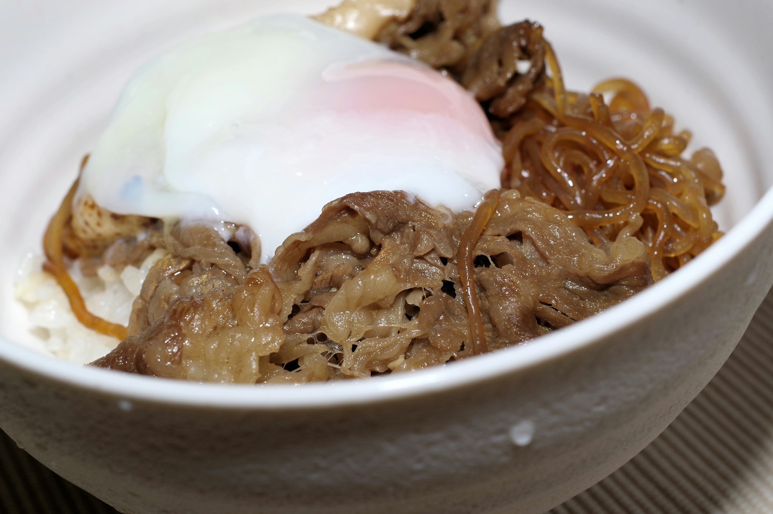 Cuenco de gyudon con huevo escalfado y fideos