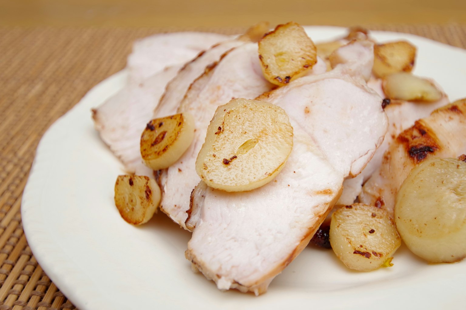 Dada ayam fillet yang diiris disajikan dengan bawang yang ditumis