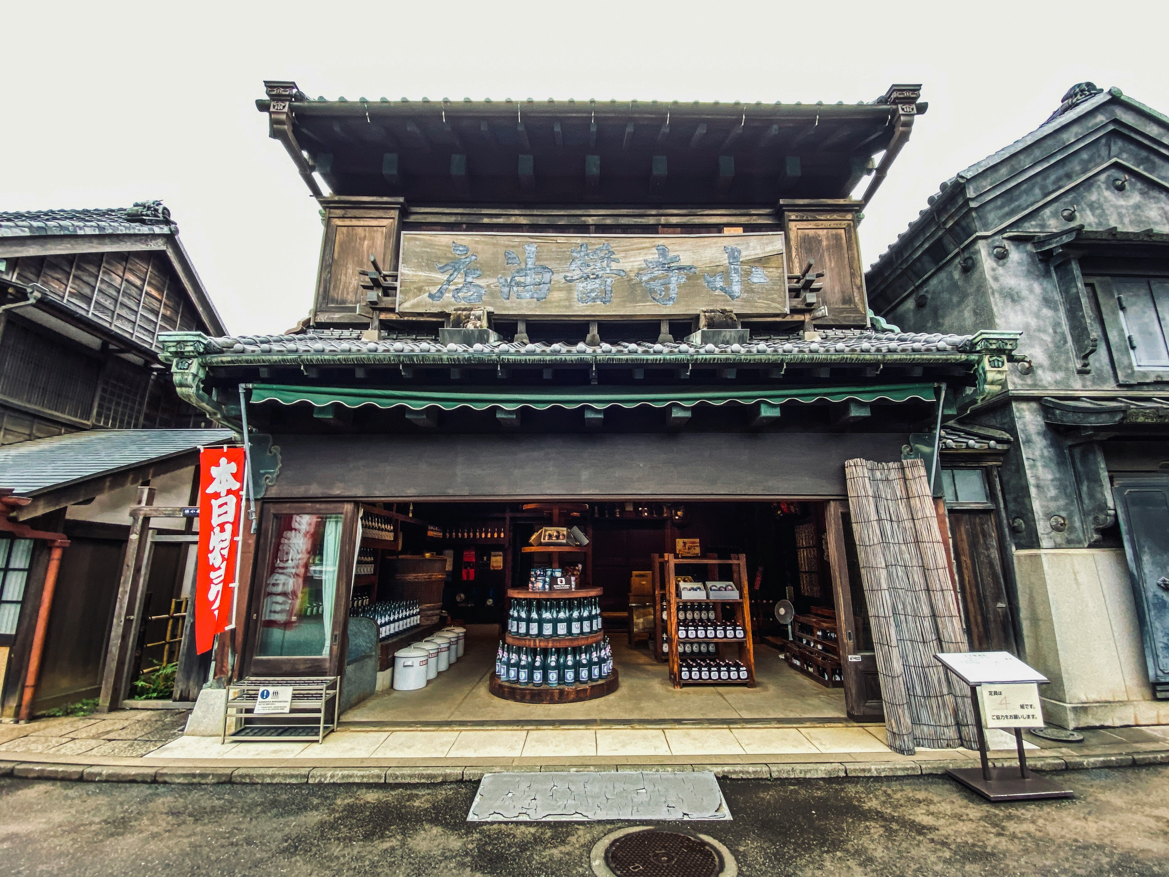 老式町屋门面前摆放的清酒桶与店招