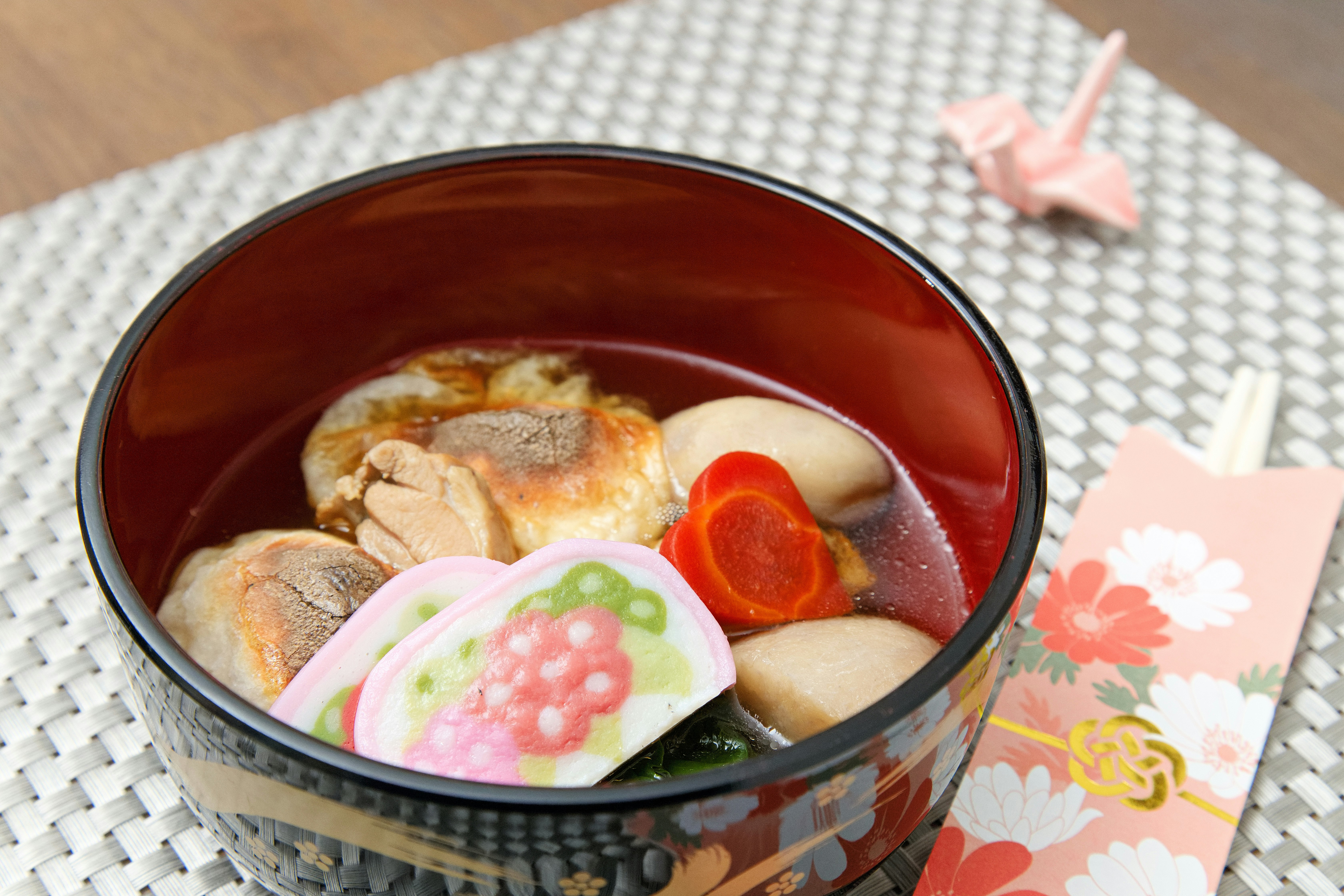 お雑煮の入ったお椀と正月飾りのある食卓