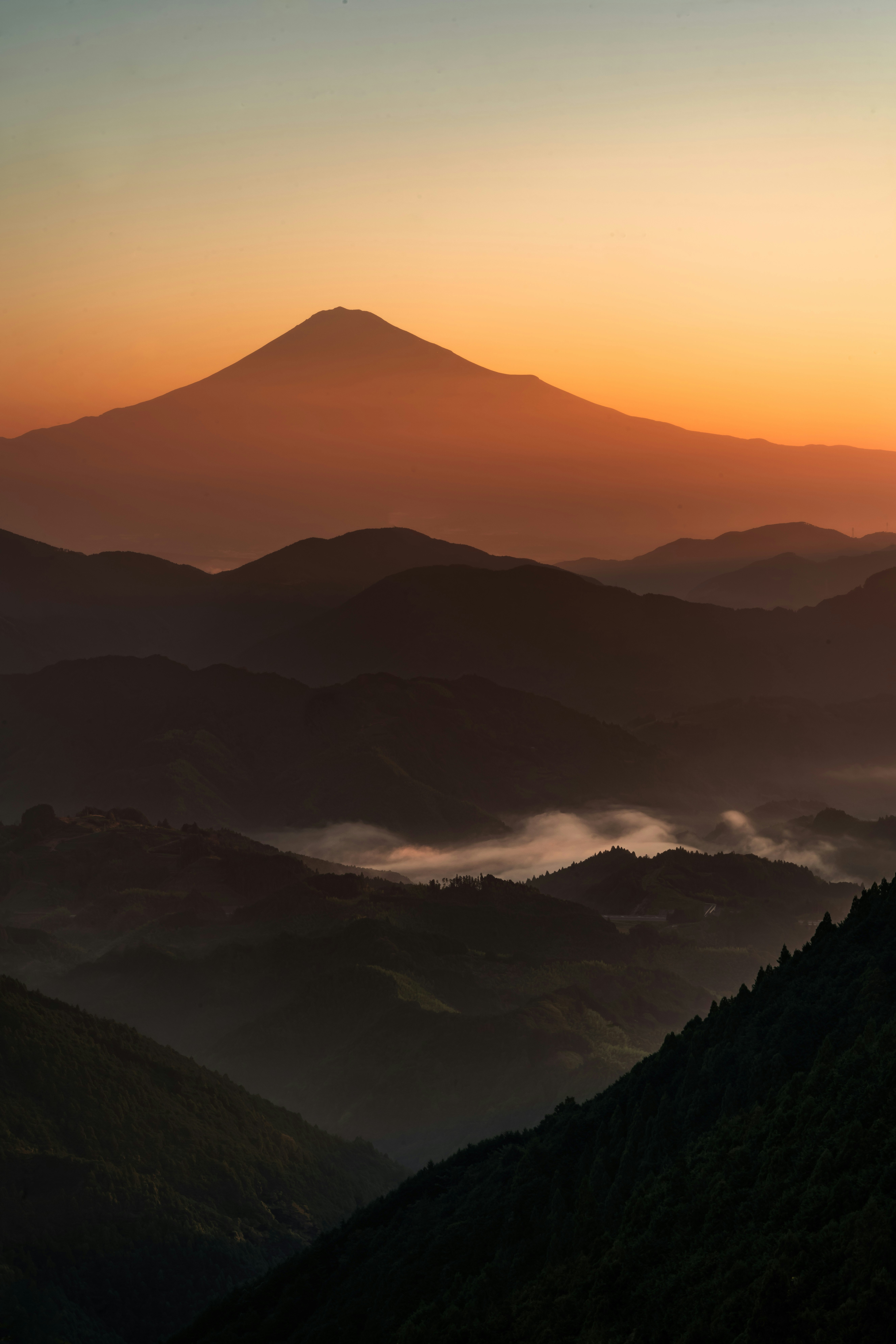夕暮れの霧に包まれた山並みのシルエット