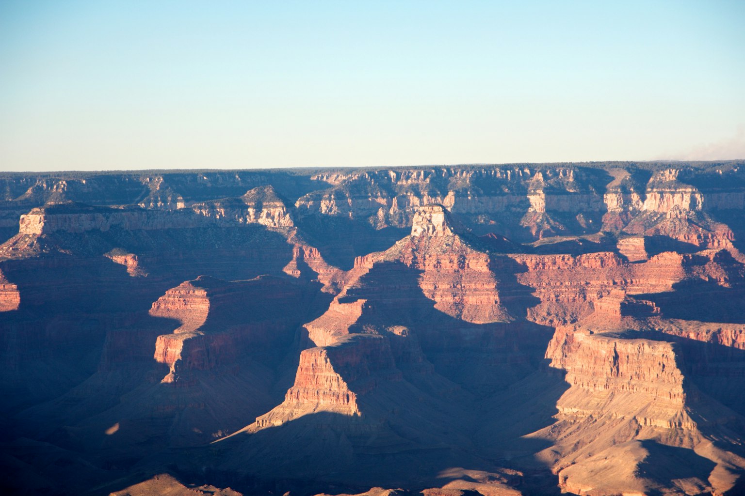Cảnh quan Grand Canyon với các khối đá màu đỏ và bầu trời trong xanh