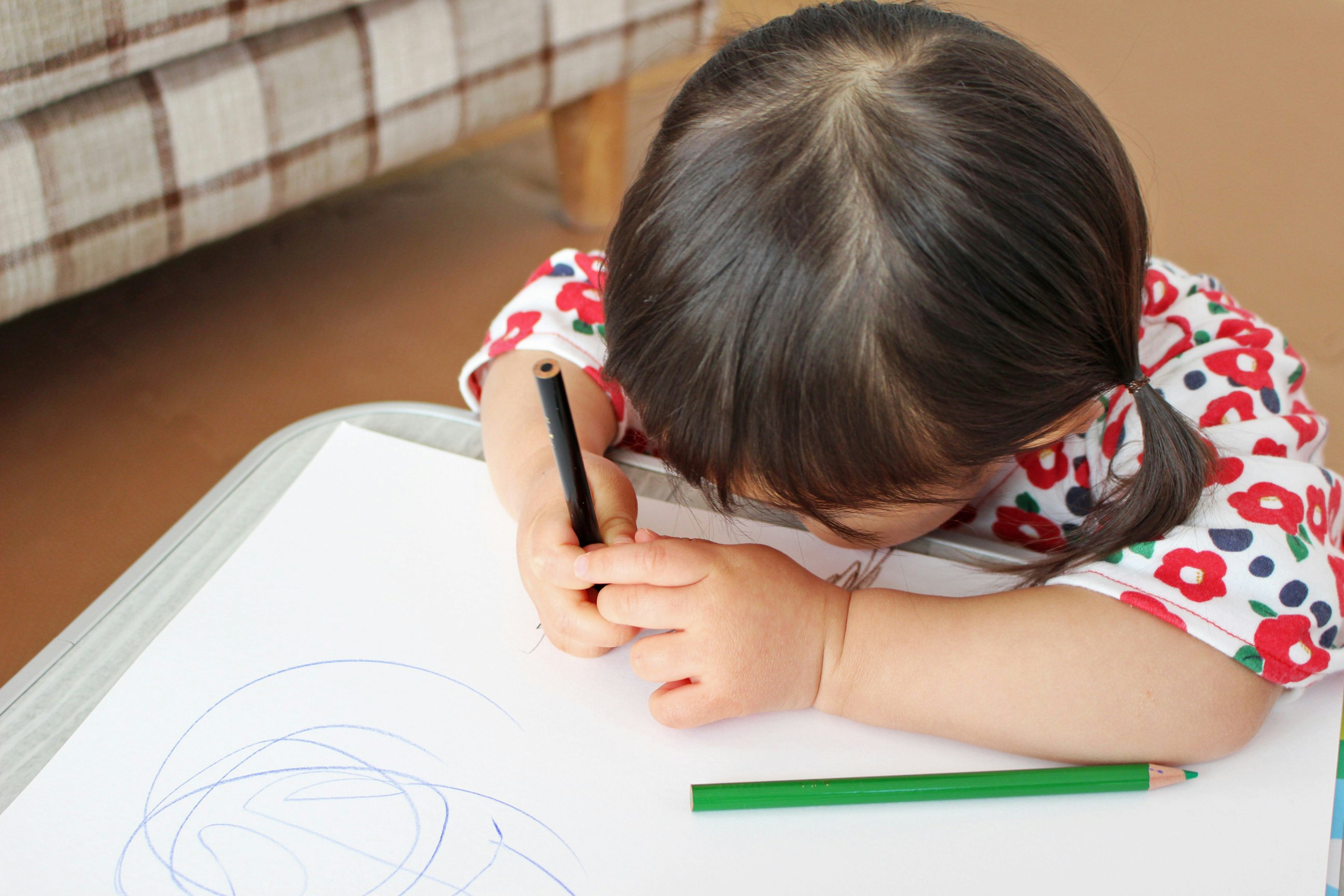 お絵かきする子どもの手元とクレヨン