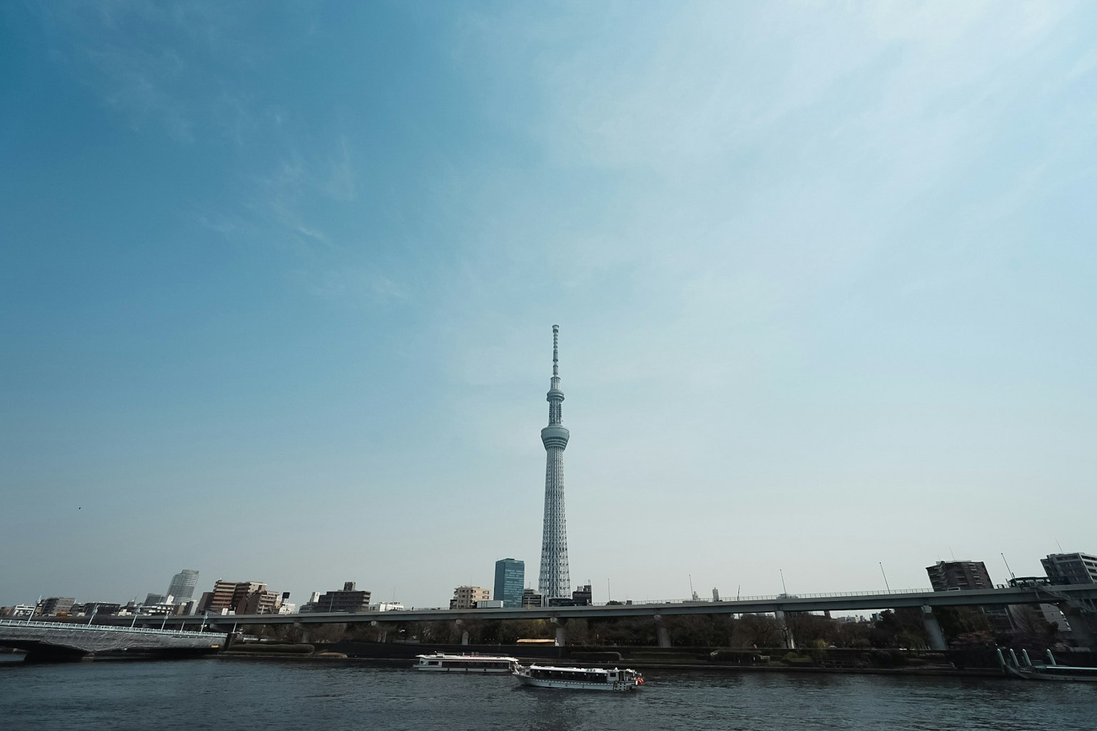 Tokyo Skytree with blue sky view featuring boats on the river