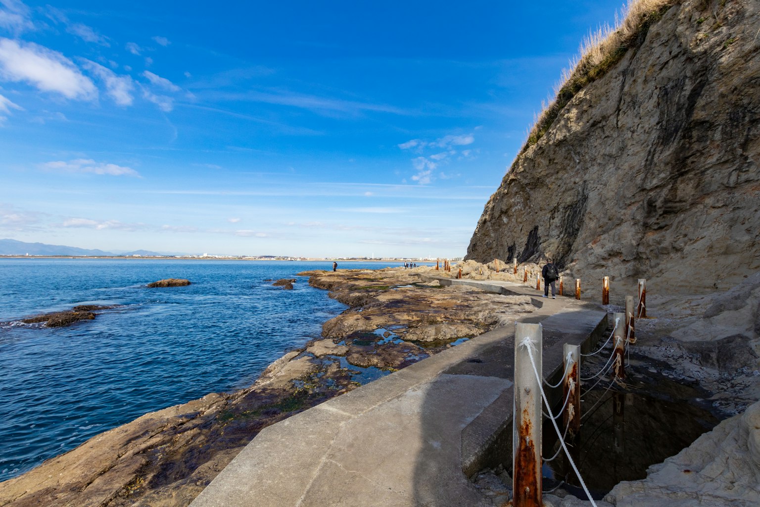 Sentiero costiero con riva rocciosa e cielo blu