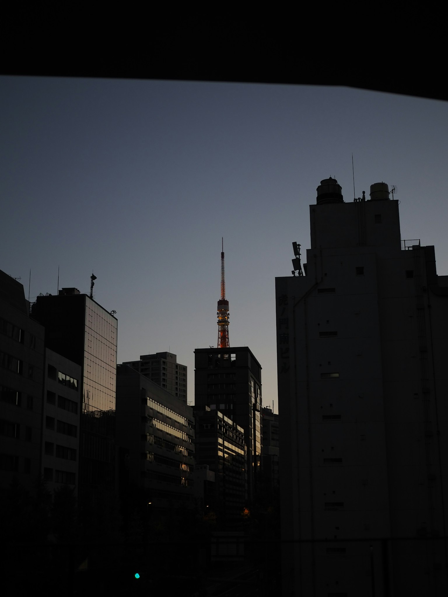 Tokyo Tower silhouetted against the dusk sky in an urban landscape