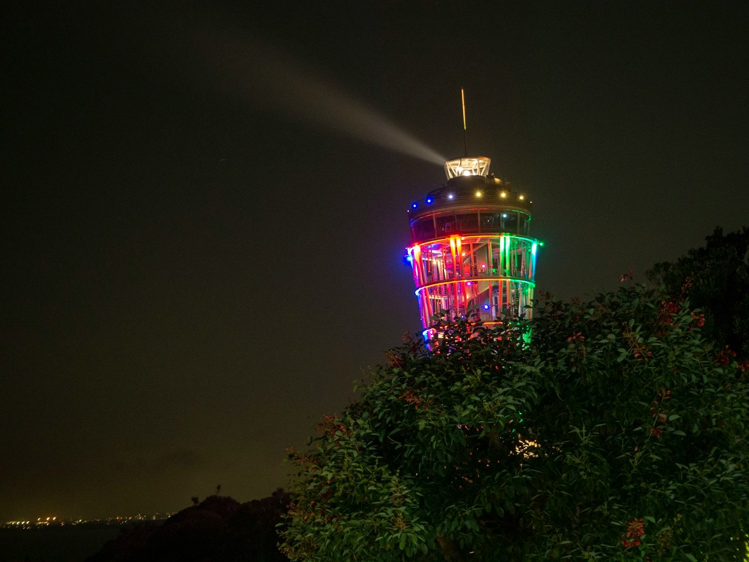 夜晚色彩繽紛的燈塔周圍綠樹成蔭