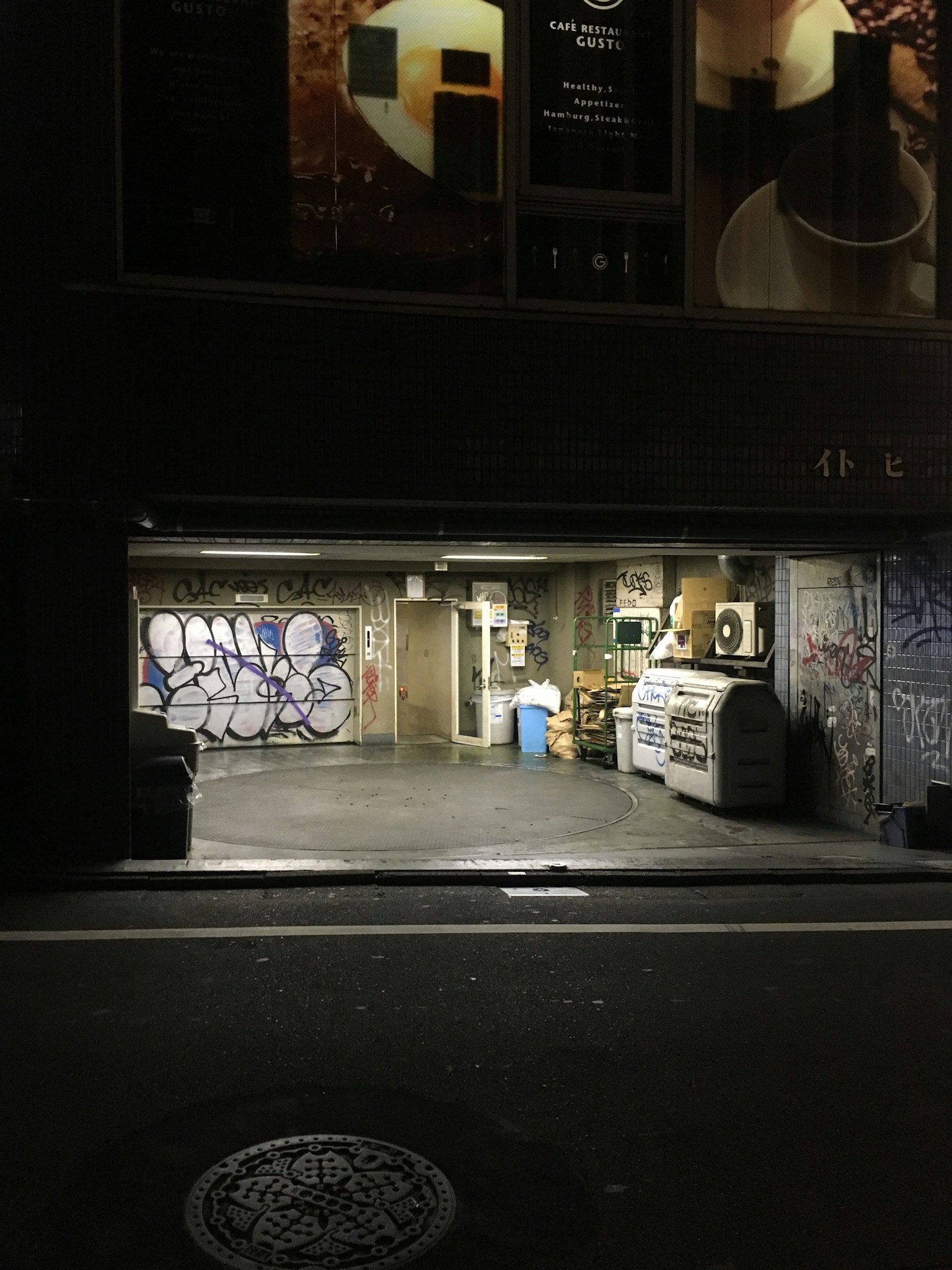Cổng garage trên con phố tối với graffiti trên tường