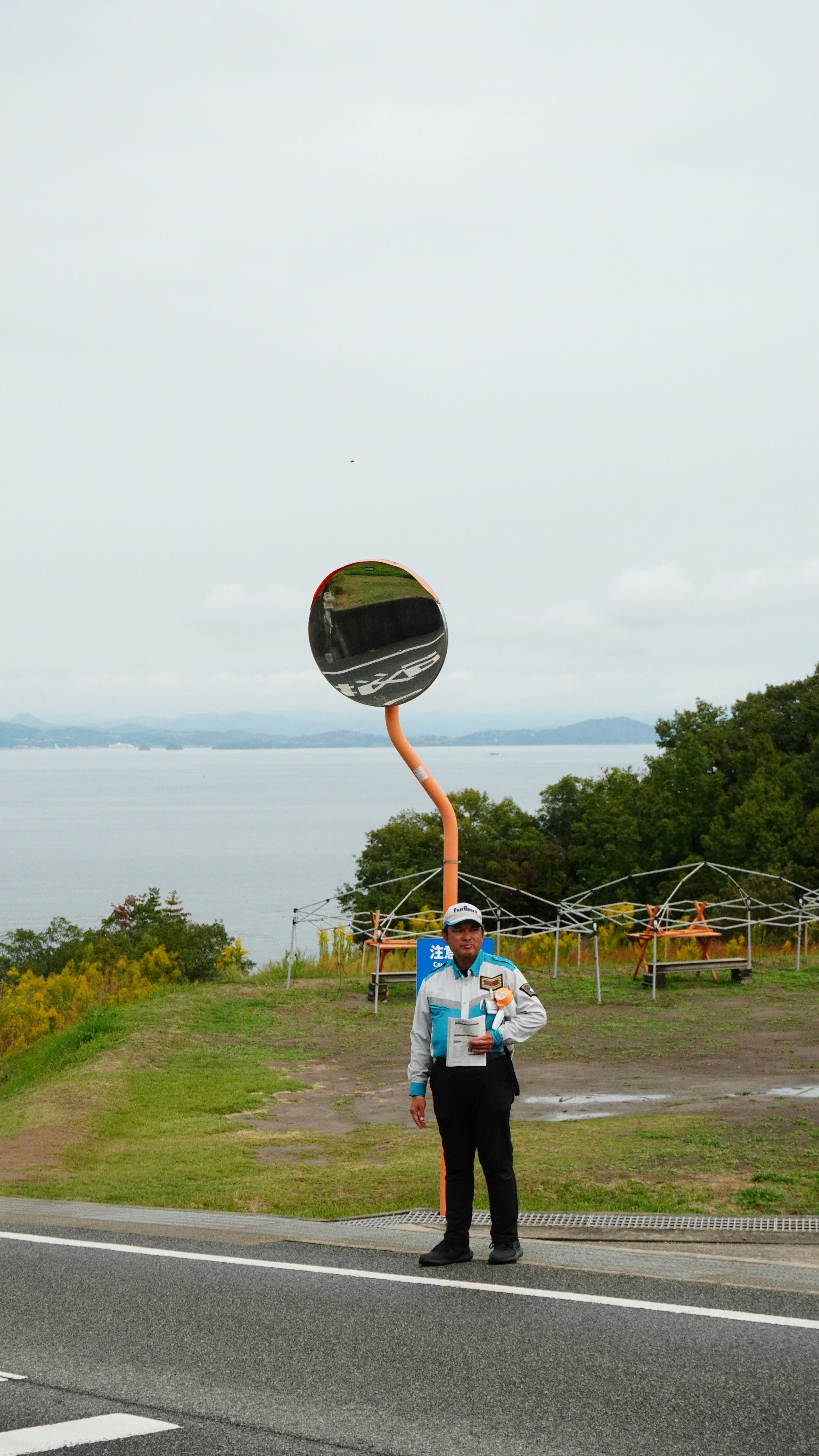 海を望む丘の道で立つ人物