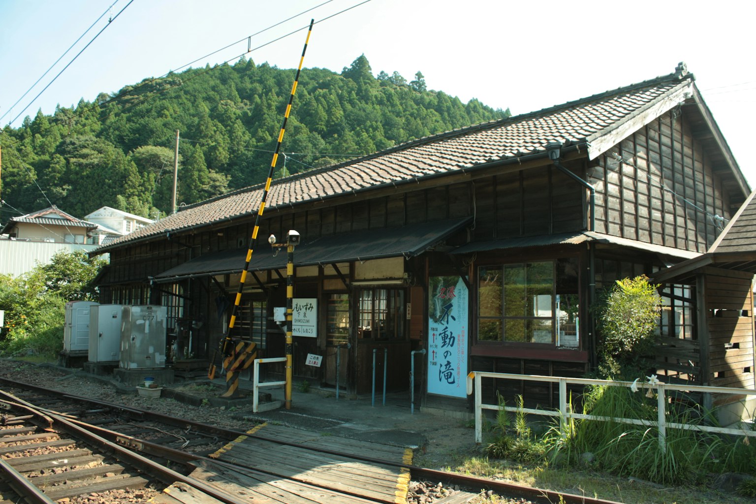 สถานีรถไฟไม้เก่ากับภูเขาเขียวขจีเบื้องหลัง