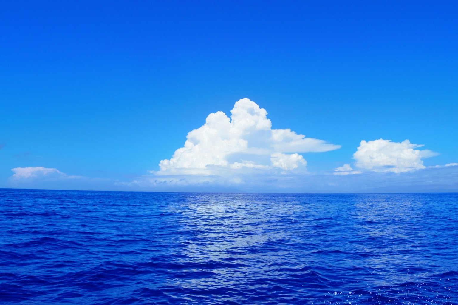 Weites blaues Meer mit fluffigen weißen Wolken