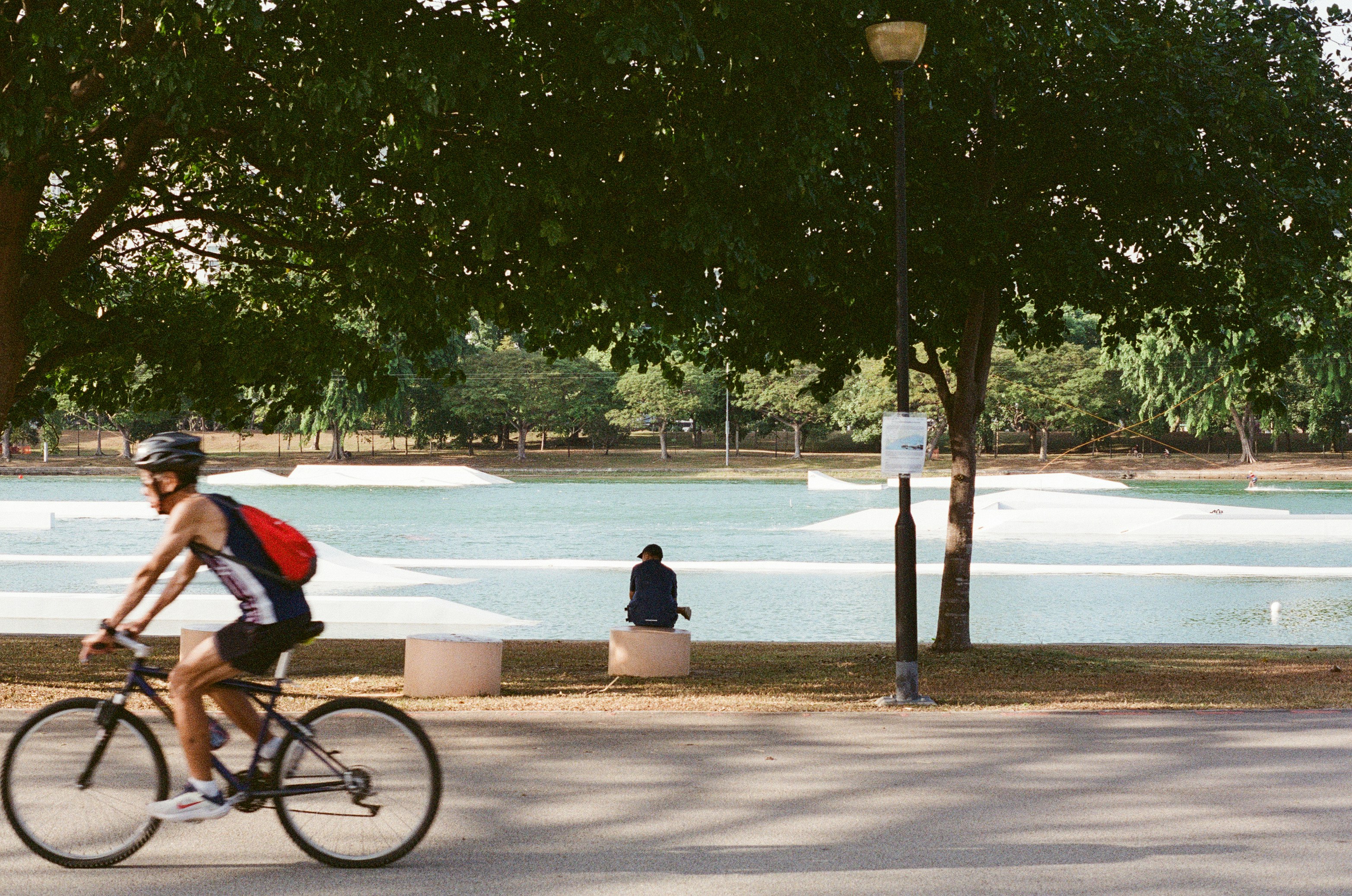 自転車に乗る人と公園の遊歩道のある風景