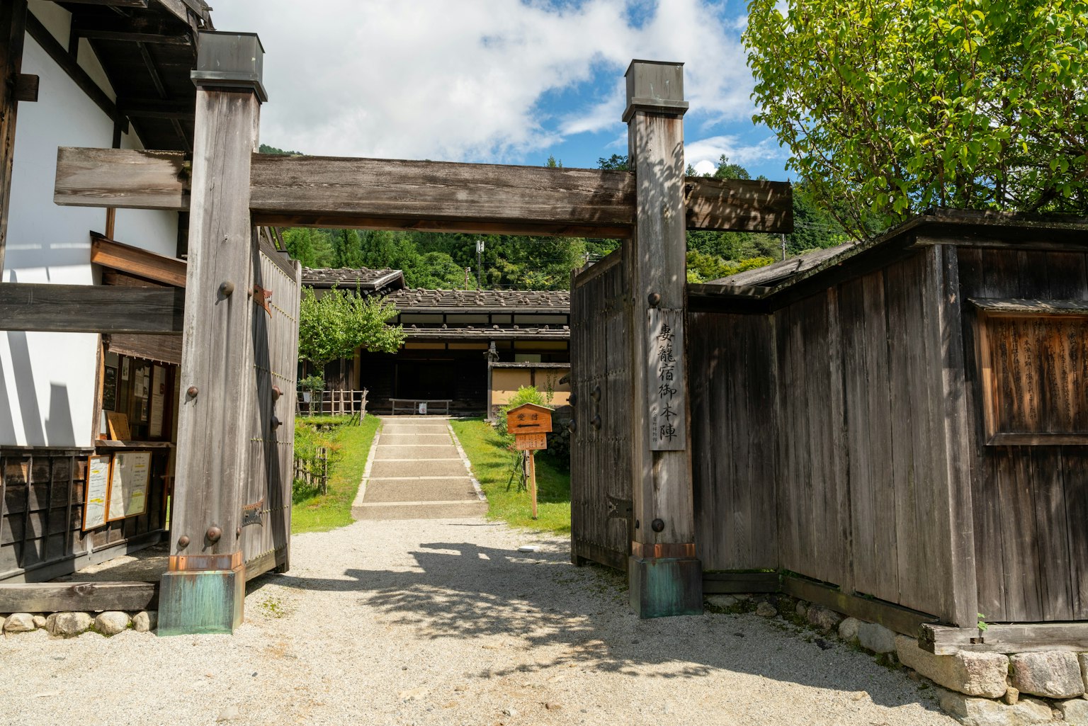 Puerta japonesa tradicional con un camino de piedra que conduce a un jardín