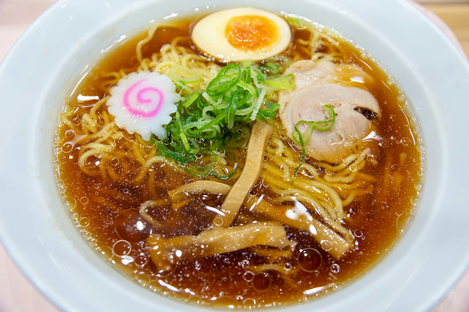 ชามราเมนอร่อยที่มีน้ำซุป เส้นหมี่ ชาชู ต้นหอม ไข่ต้ม และนารูโตะมากิ