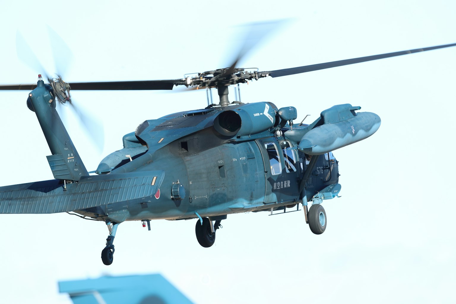 Image of a helicopter in flight with blue paint and rotating blades