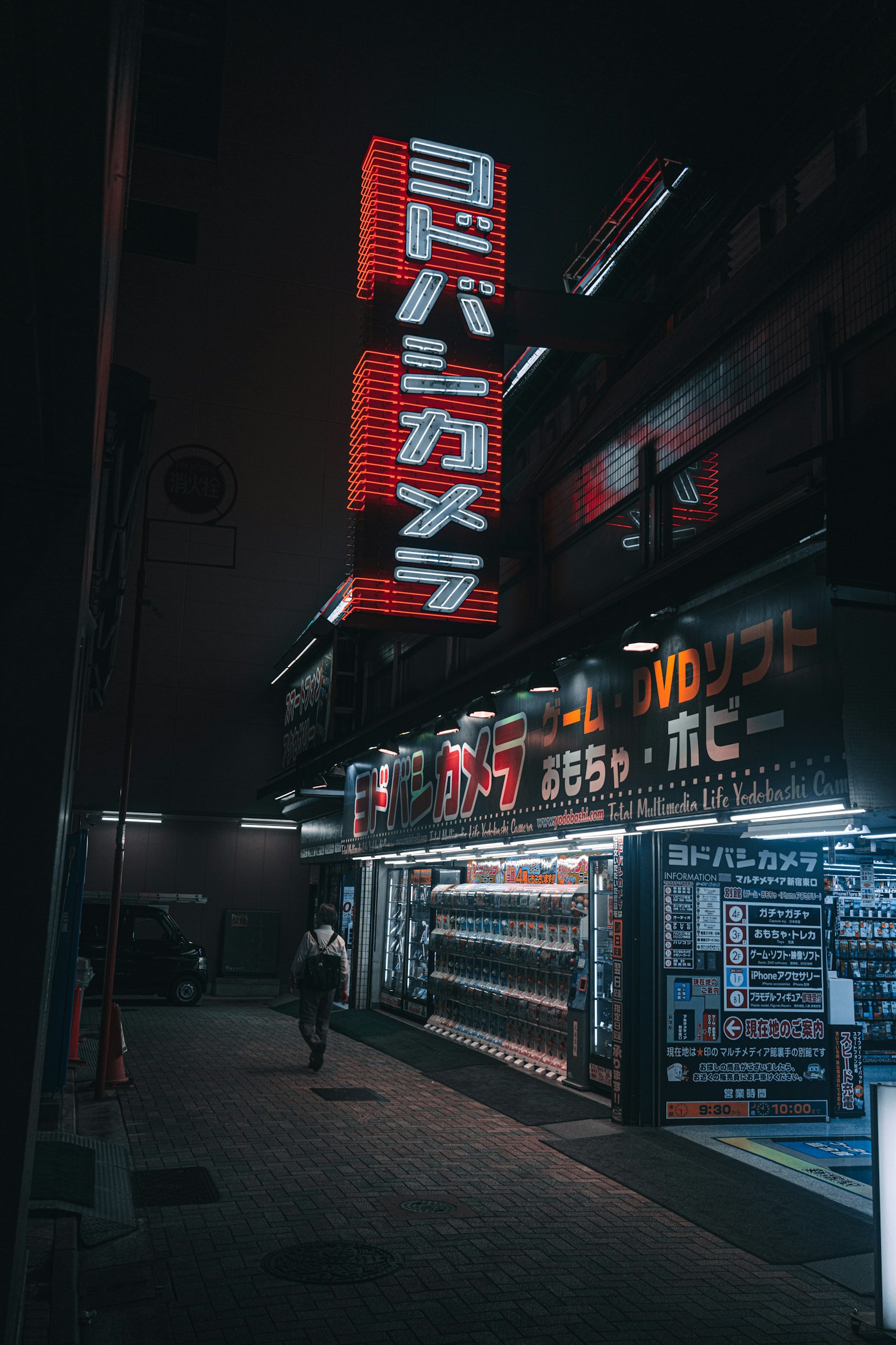 Cartel y tienda Yodobashi Camera de noche en una esquina de la ciudad
