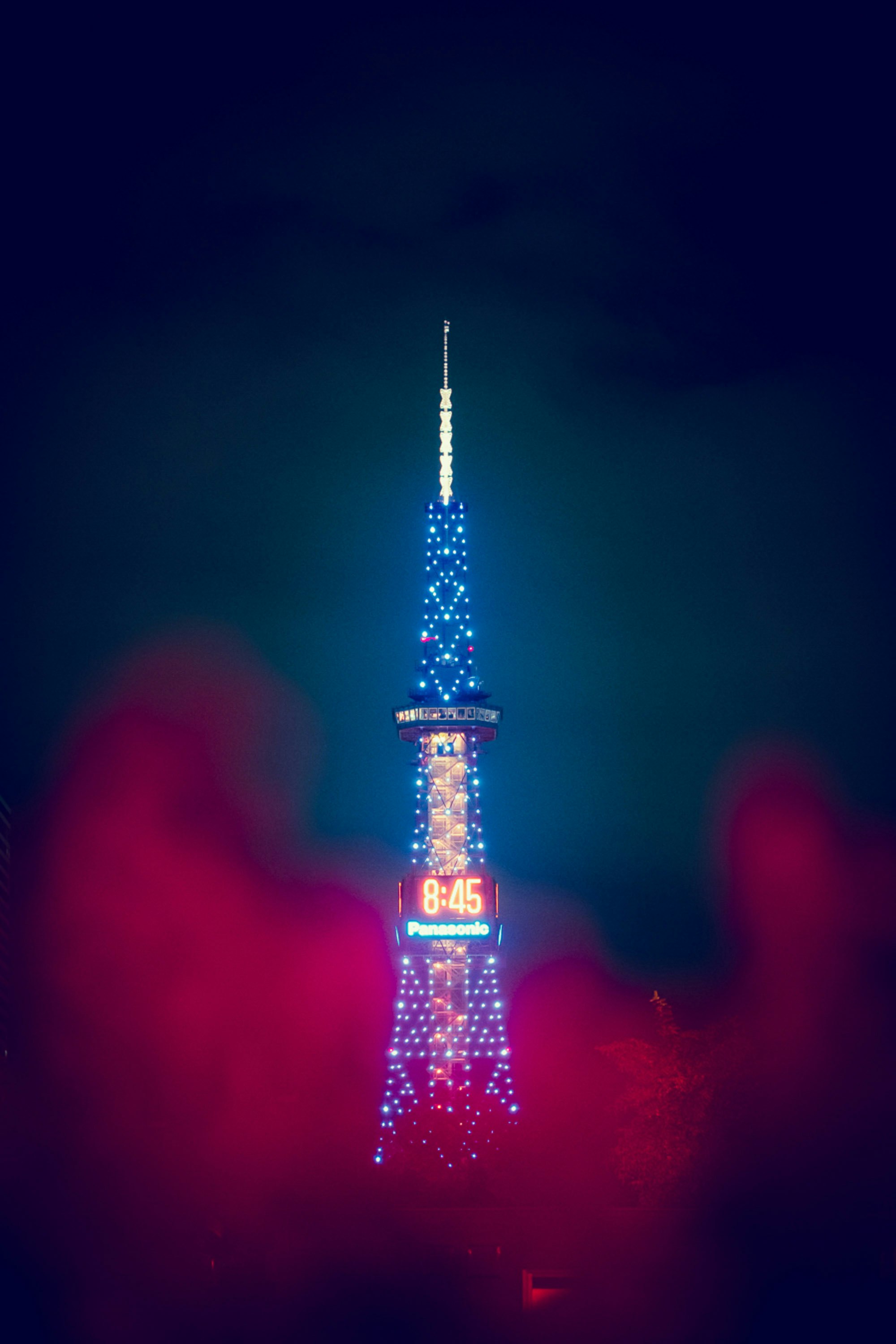 夜空にそびえる光の塔とイルミネーション