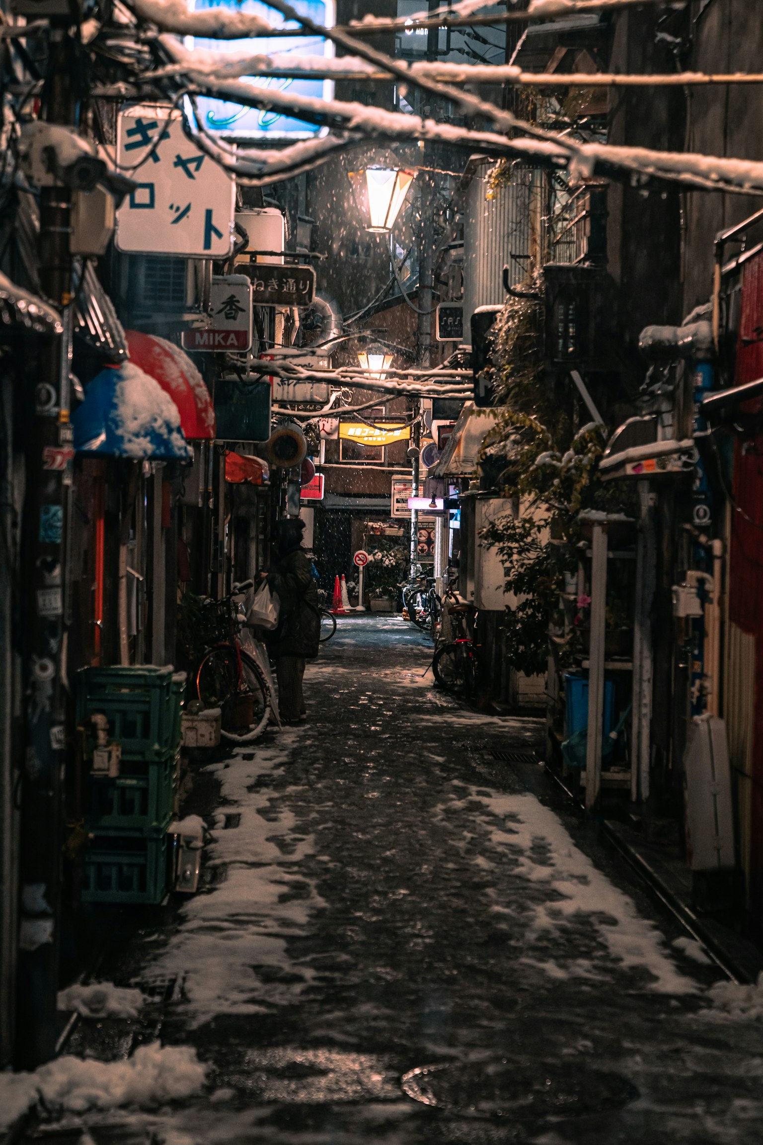 被雪覆盖的狭窄巷道，夜晚的街灯