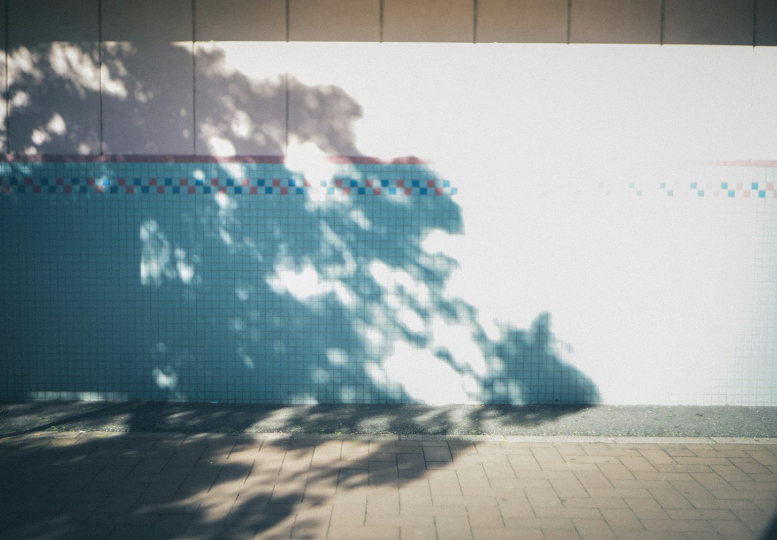 Escena simple con sombras proyectadas en una pared azul