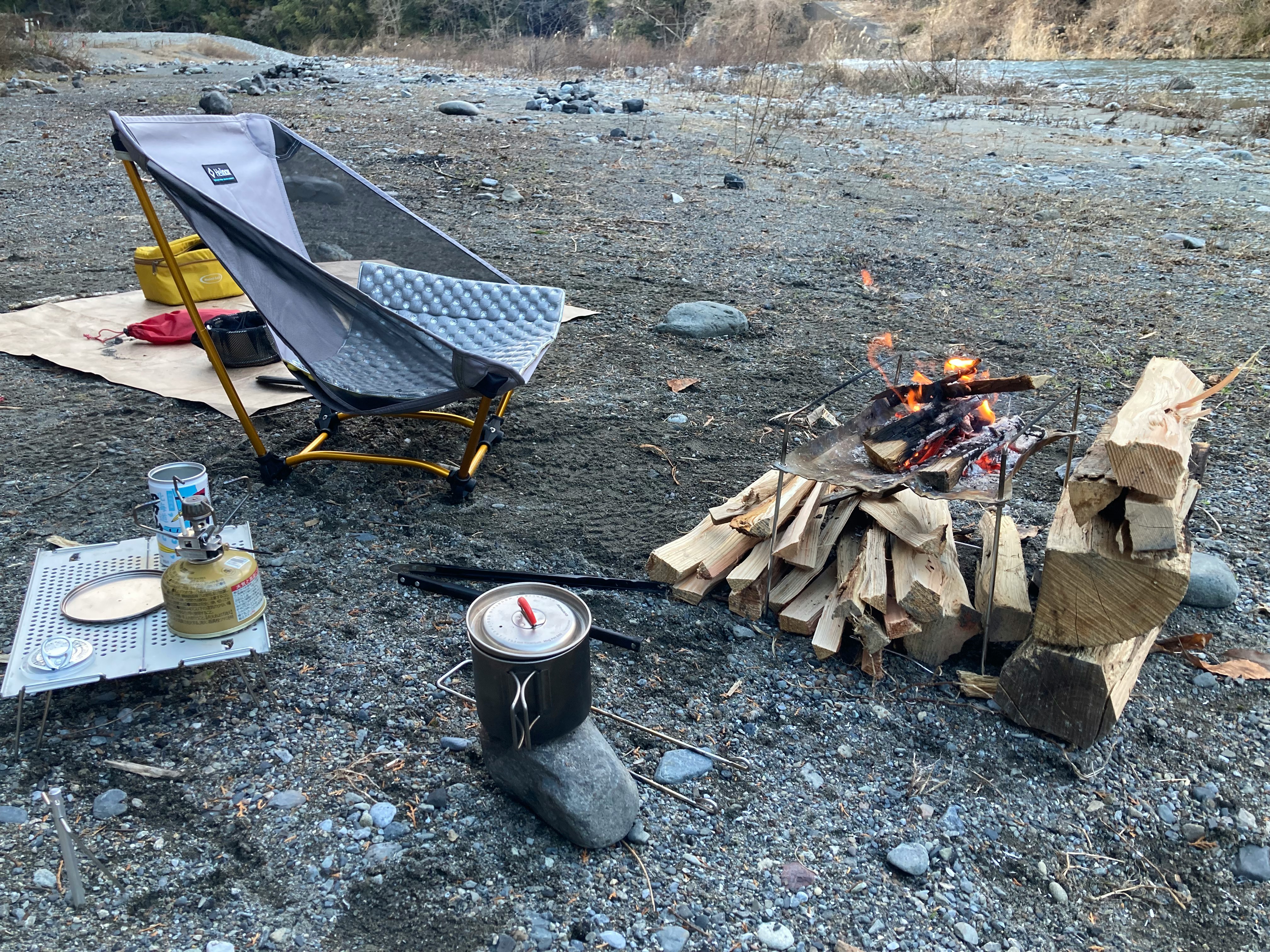 campfire avec chaise de camping et matériel de cuisine sur un site de camping en plein air