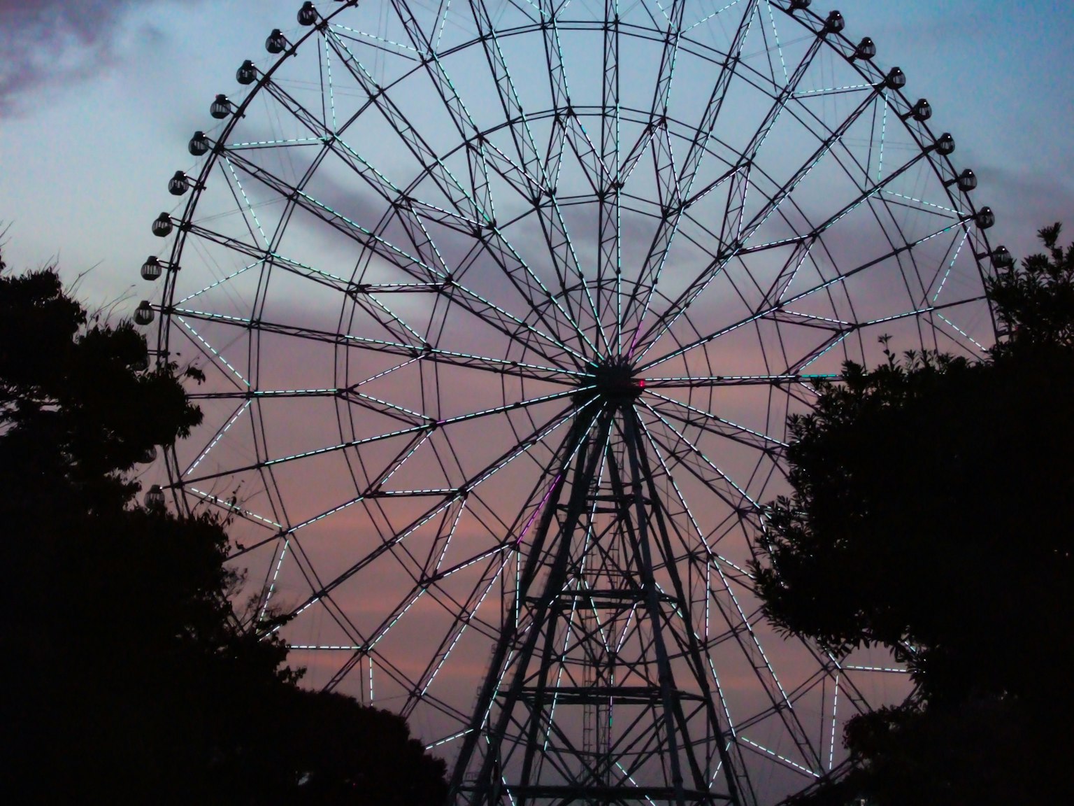 Silhouette d'une grande roue contre un ciel au coucher de soleil