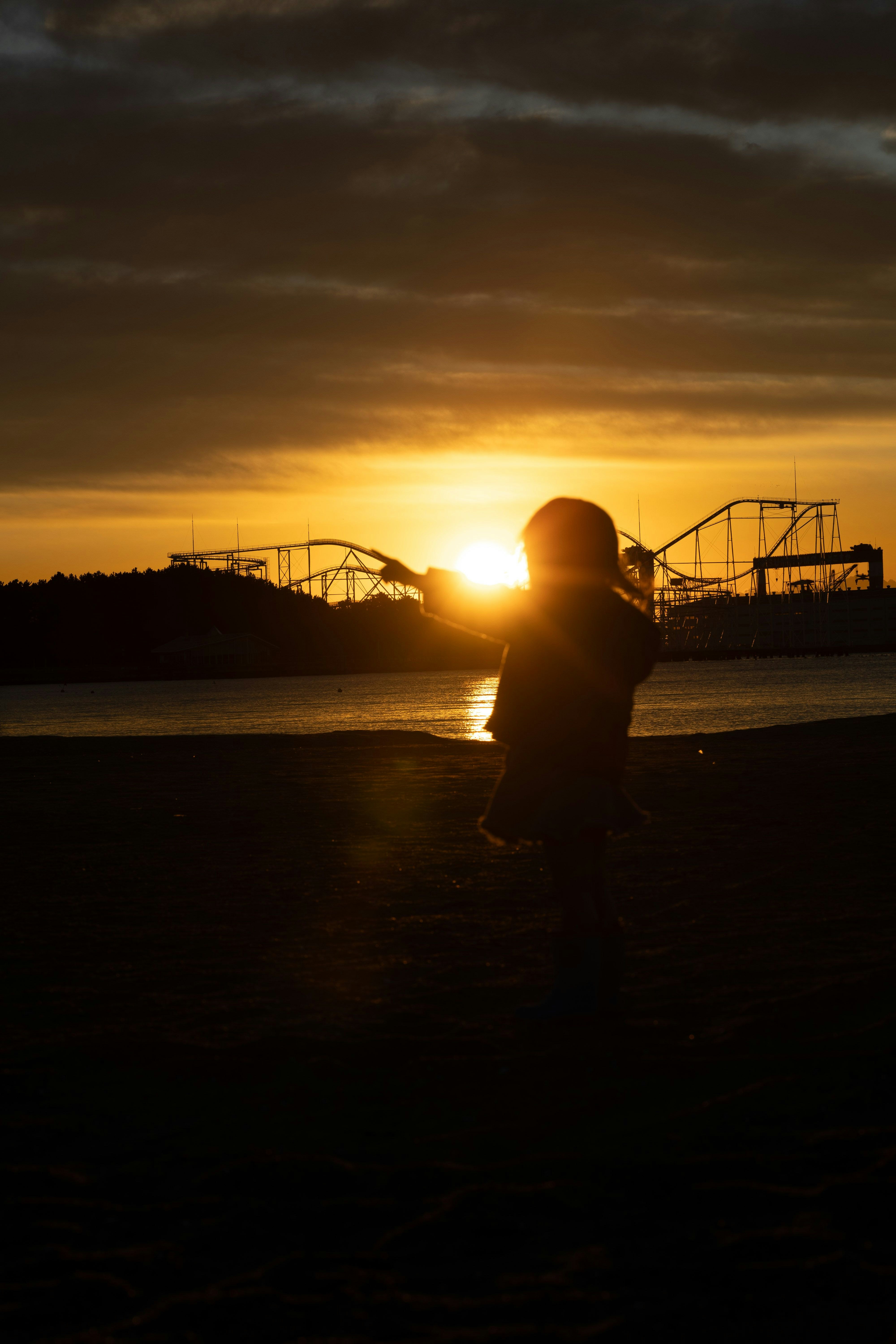 夕日に照らされる海辺でシルエットの人物
