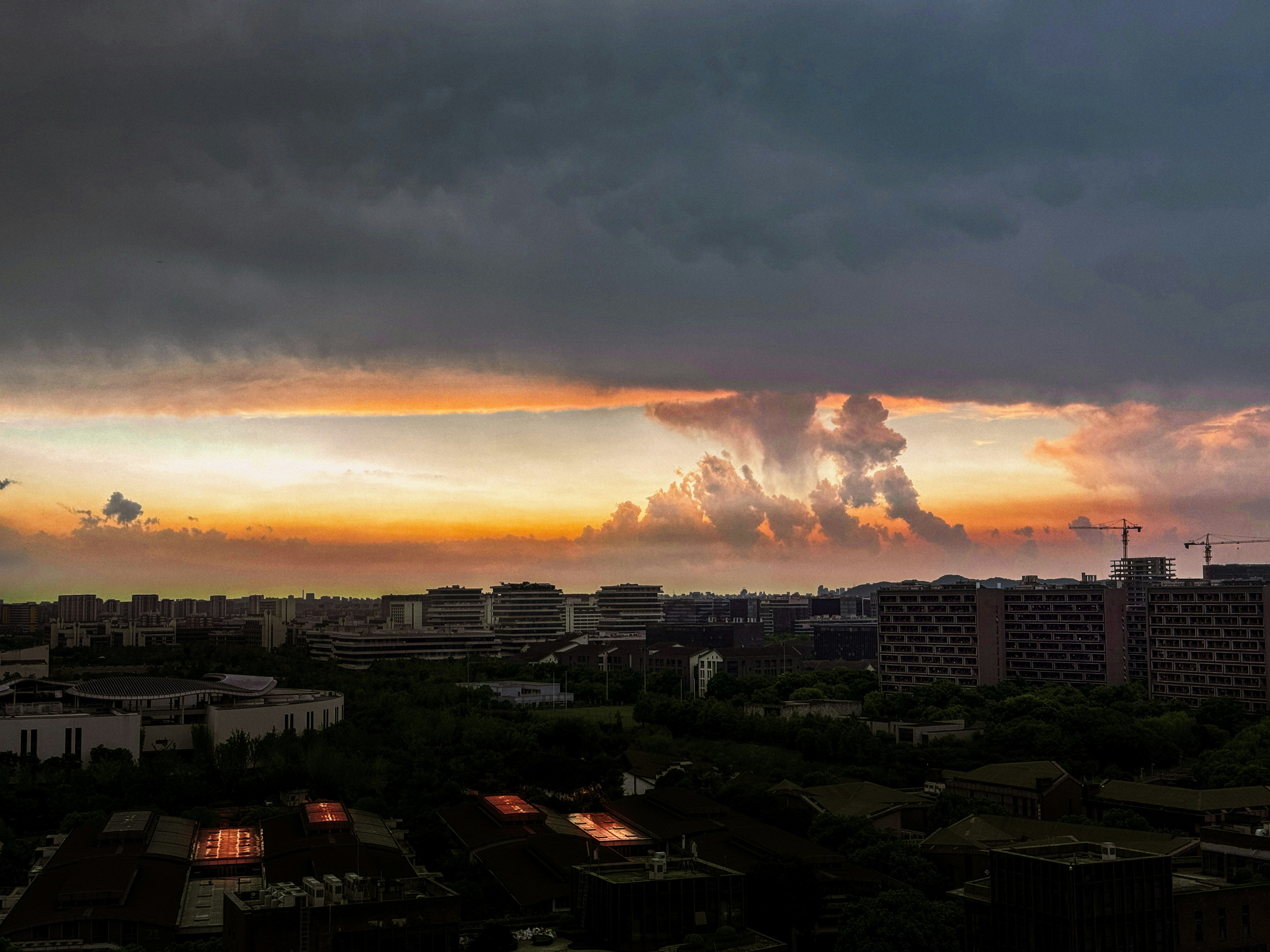 夕焼けの空と雲、住宅街の屋上が広がる眺め
