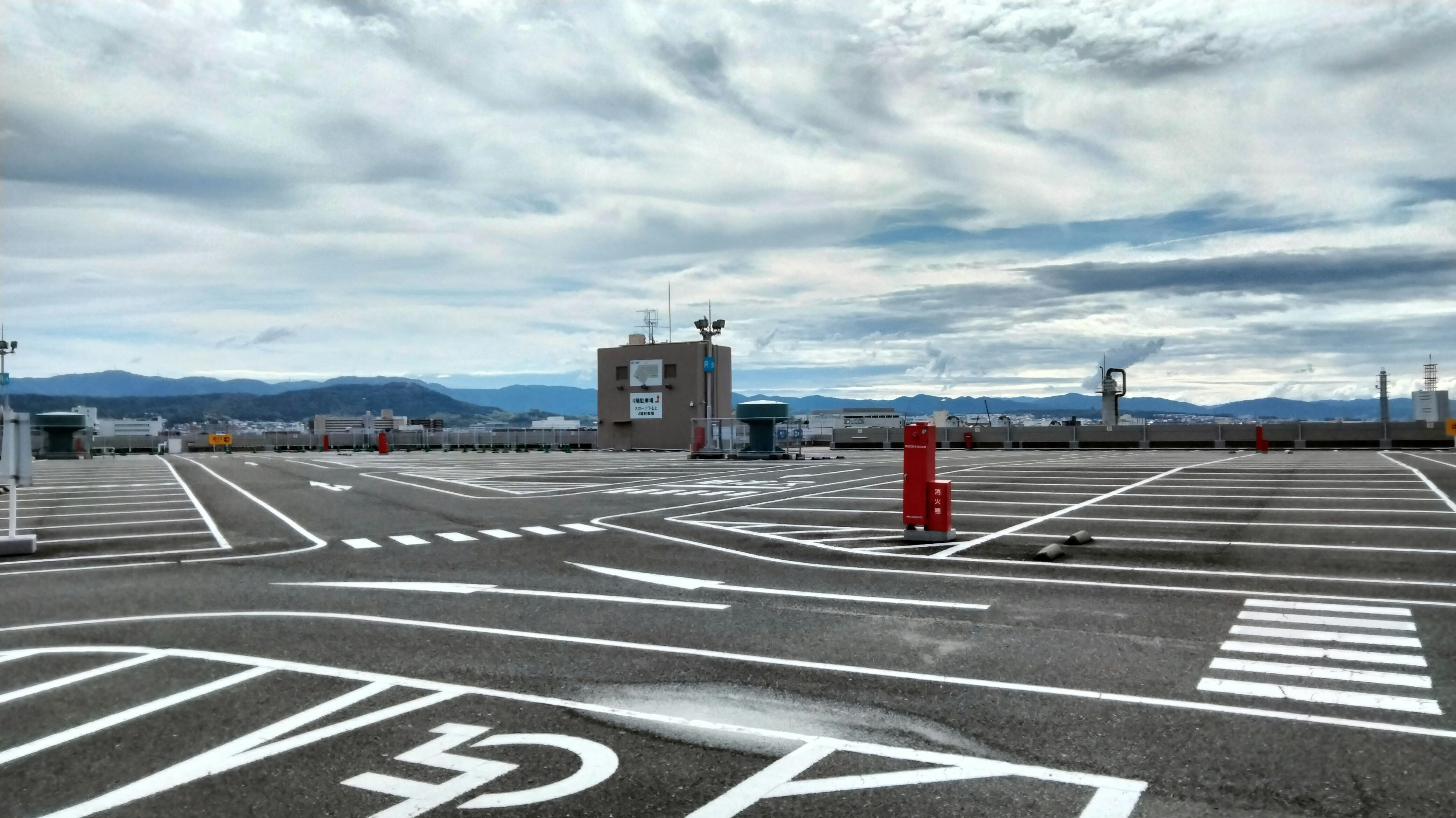 breiter Kreuzungsbereich mit Straßenmarkierungen und Ampeln