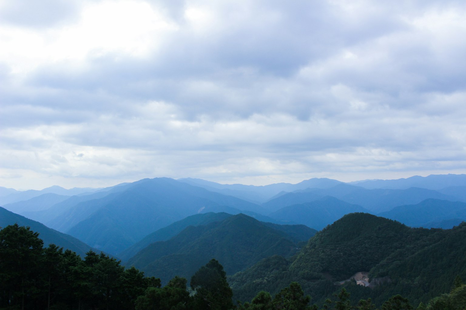 ทิวทัศน์ภูเขาสีน้ำเงินใต้ท้องฟ้าหมอกเมฆ
