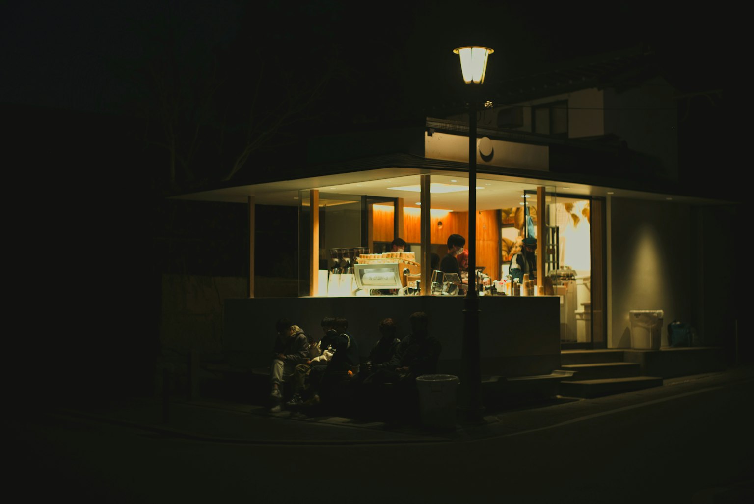 Esterno di un caffè illuminato di notte con luce calda