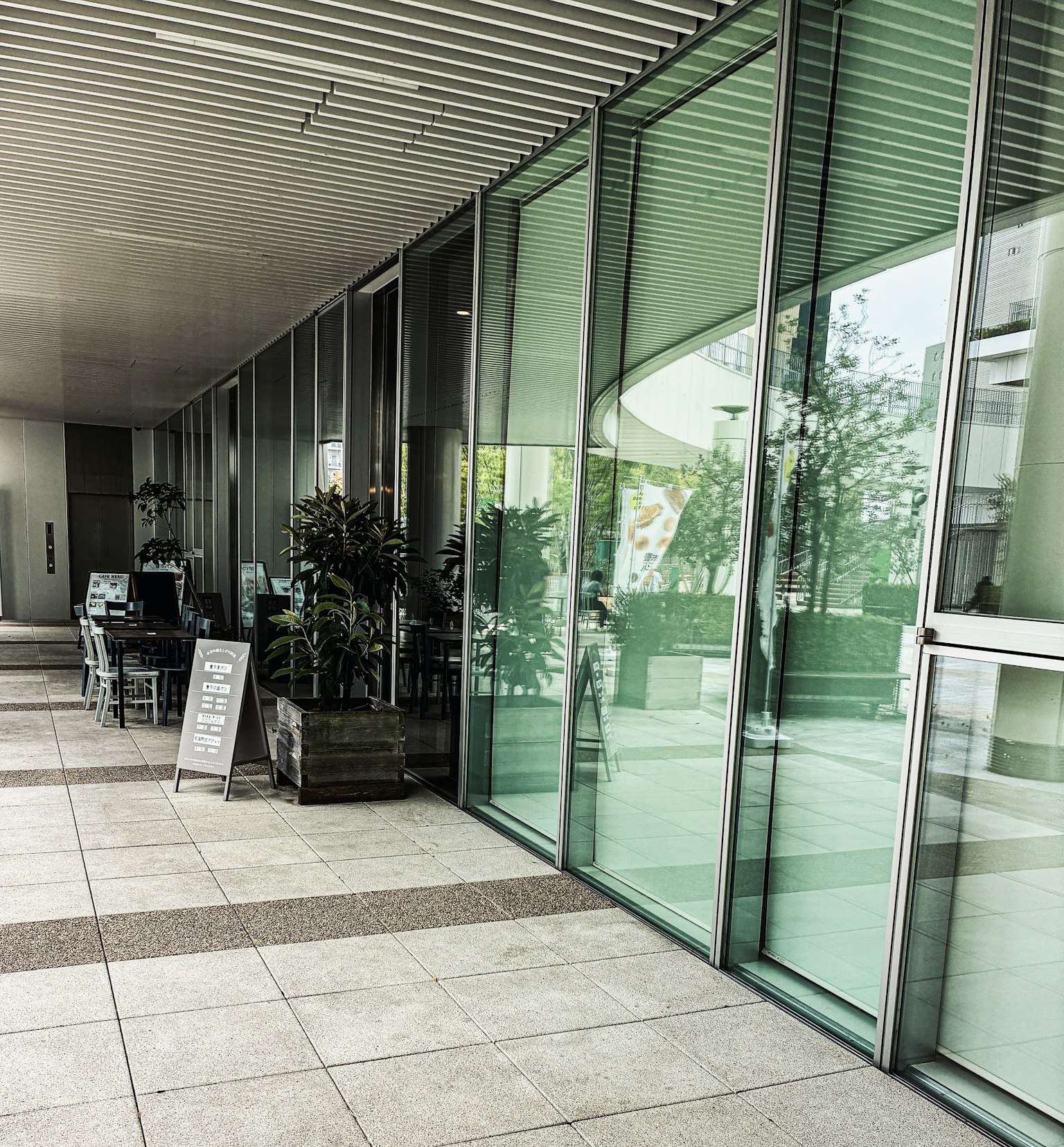 Ngoại thất tòa nhà hiện đại với tường kính và cây trong chậu