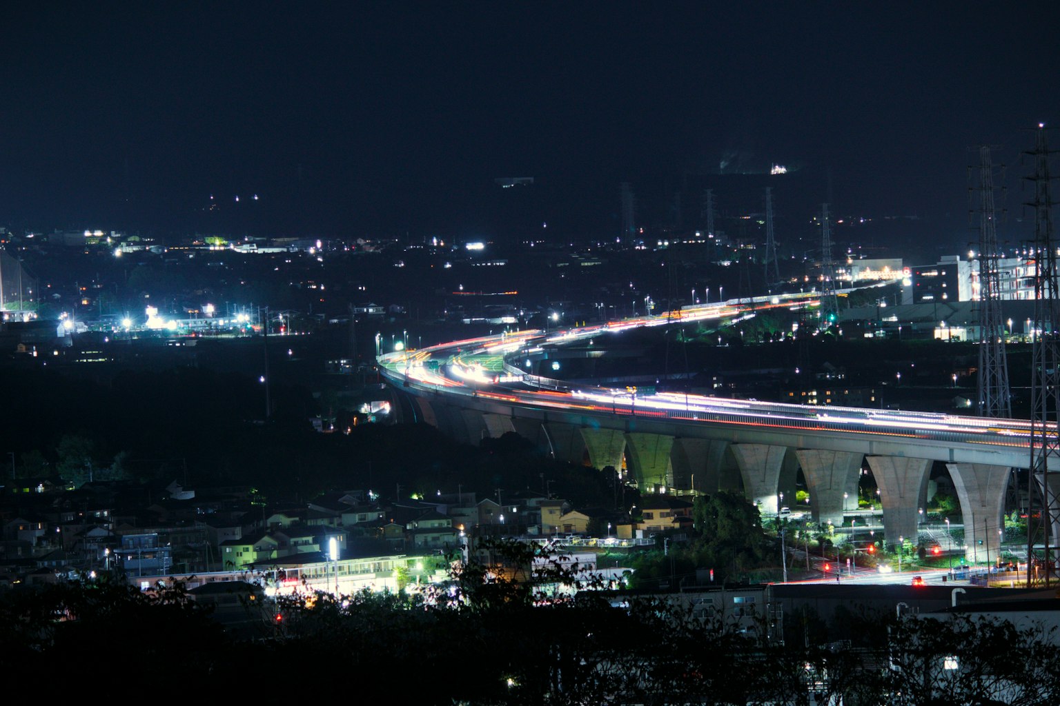 Jalan layang di malam hari dengan jejak cahaya kendaraan