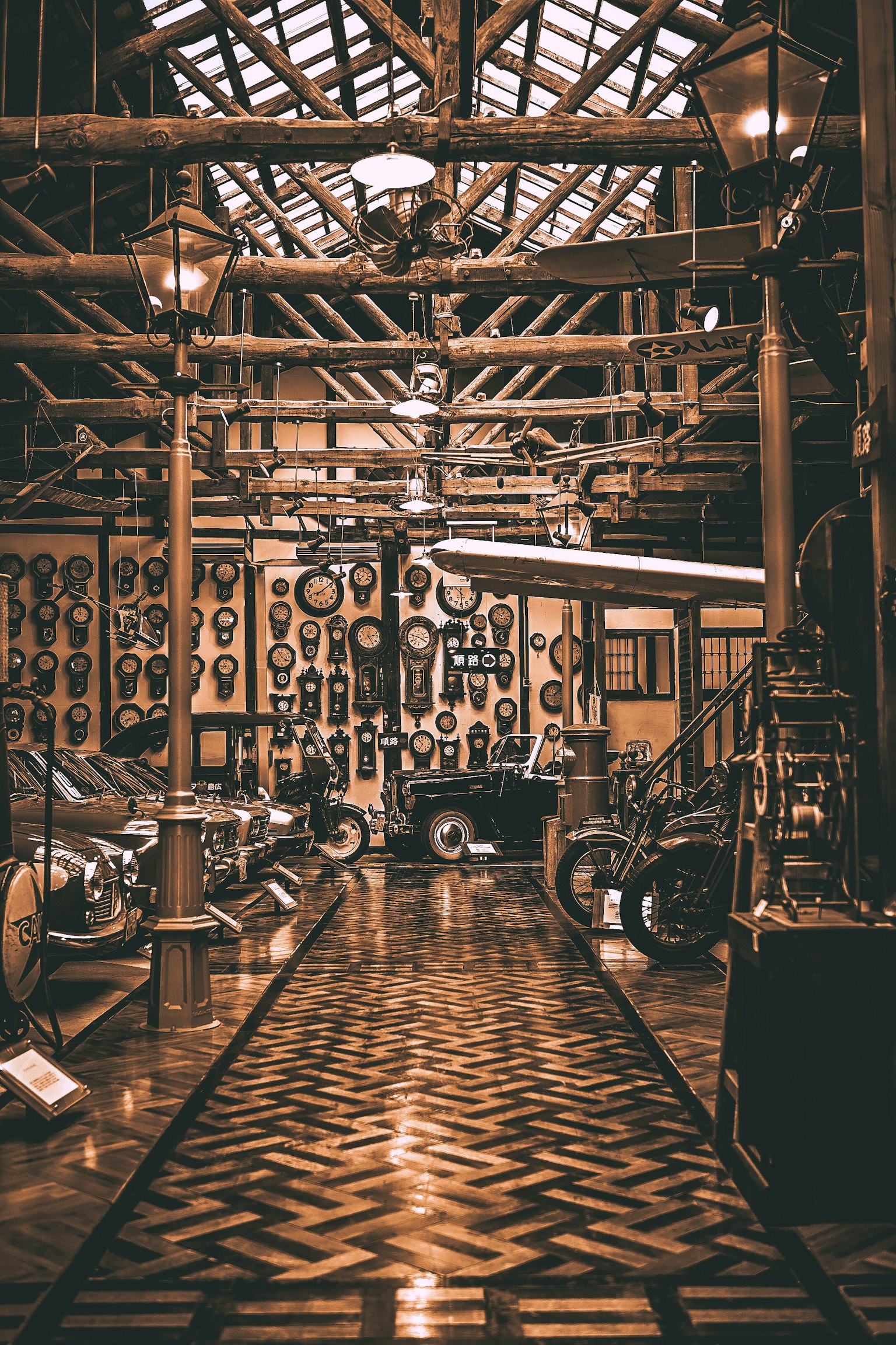 歴史的な車両と装飾が並ぶ博物館の内部木製の梁とランプが特徴的