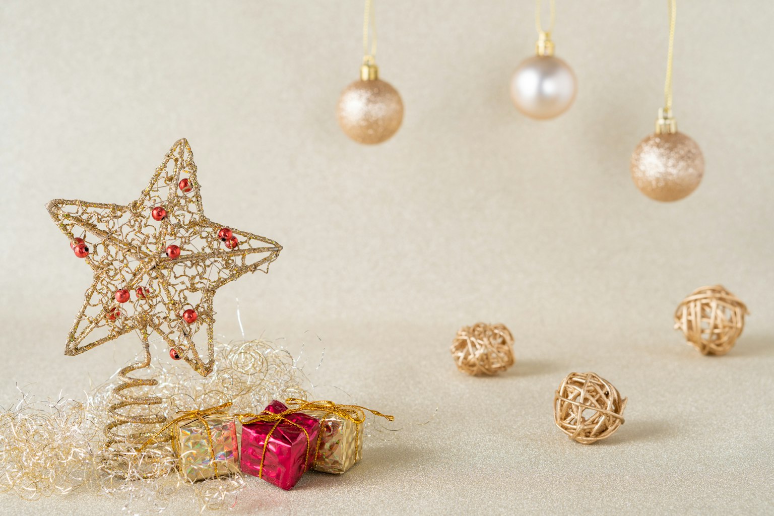 Ornement en forme d'étoile décoratif et boules roses avec de petits cadeaux emballés sur un fond doux