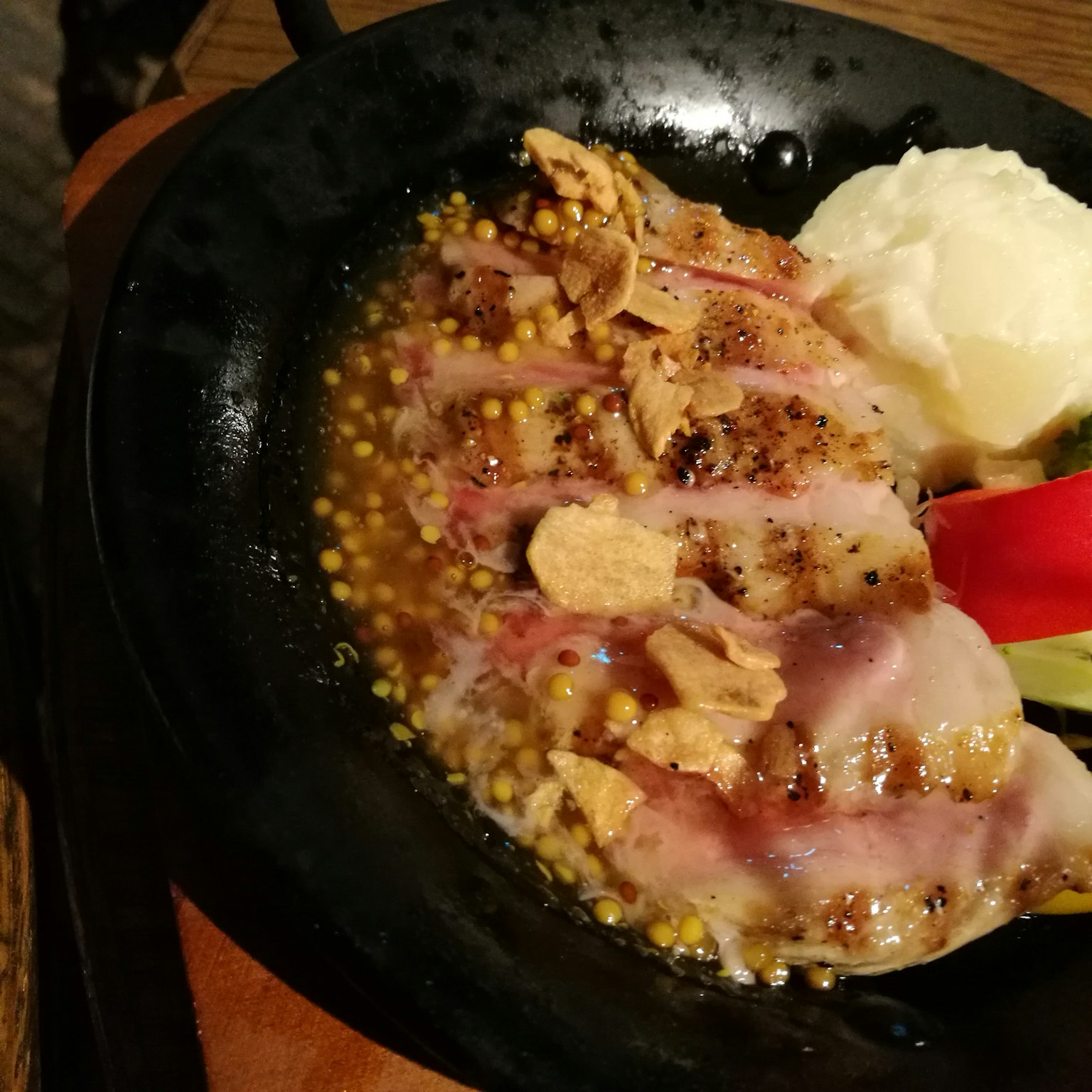 Piatto di pollo sfrigolante servito su una piastra calda con purè di patate e verdure