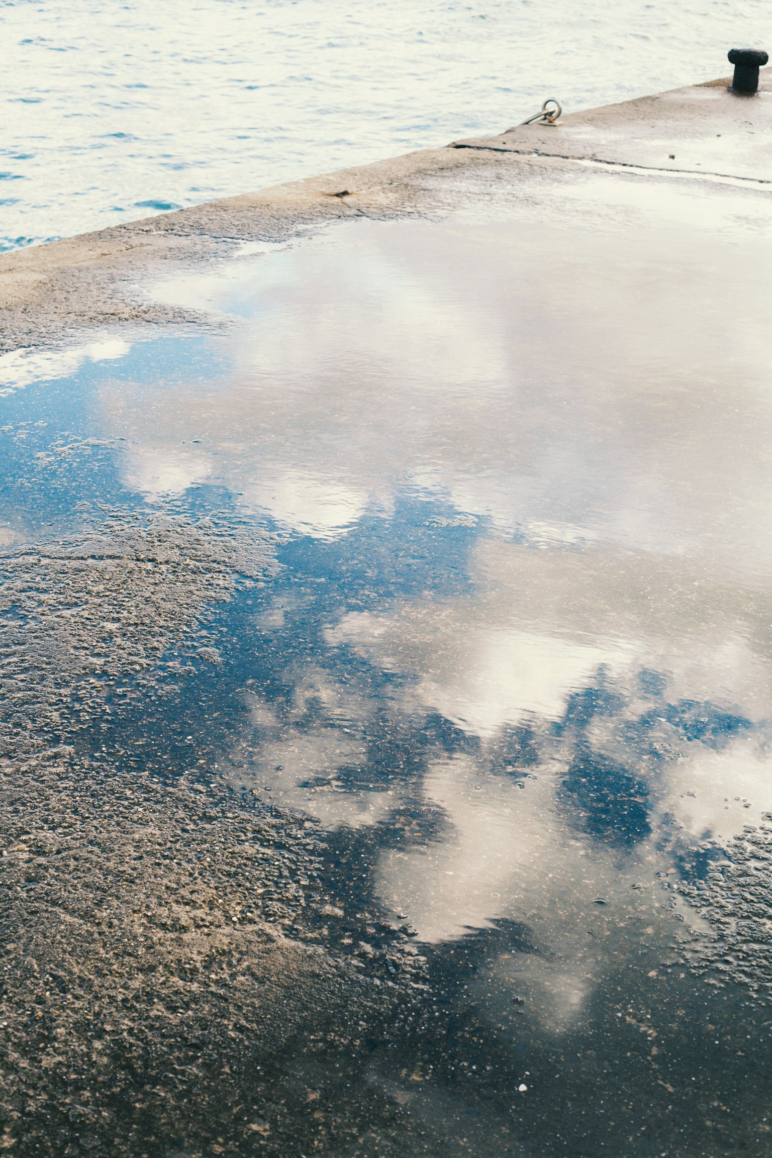 Reflet des nuages et du ciel bleu dans une flaque d'eau