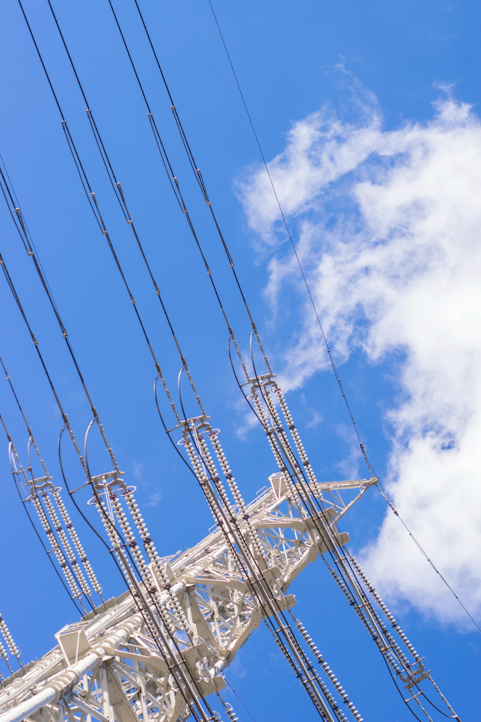 Palo elettrico e cavi contro un cielo blu