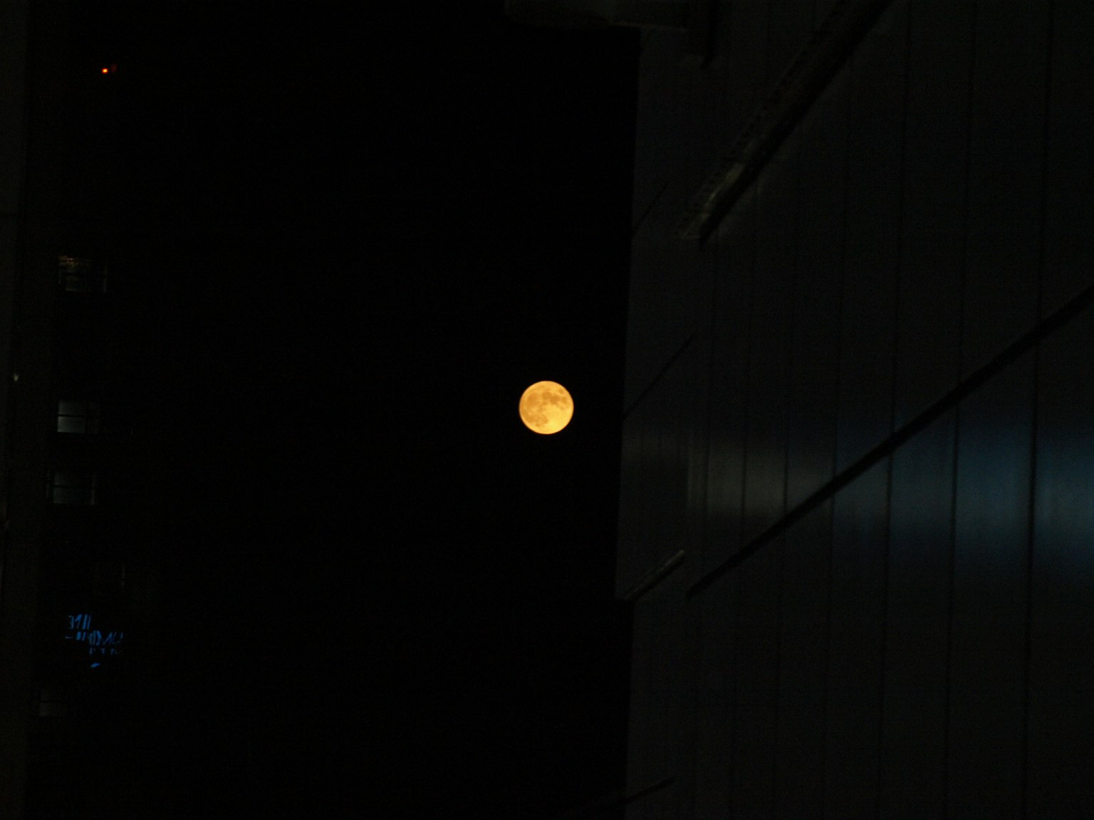Lune orange brillante dans le ciel nocturne avec un fond sombre