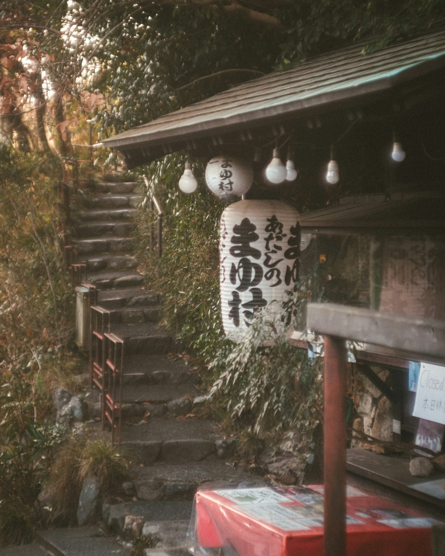 ทิวทัศน์ที่สวยงามของร้านชาแบบญี่ปุ่นเก่าที่มีบันไดหินและโคมไฟ
